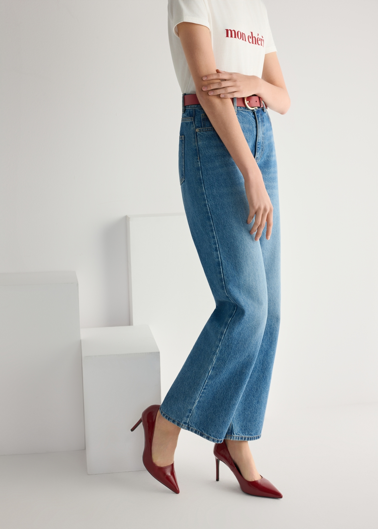 Czerwone skórzane szpilki damskie BUTYD-1131A-4B(W26), widok produktu od boku na modelce, widoczna połowa sylwetki.