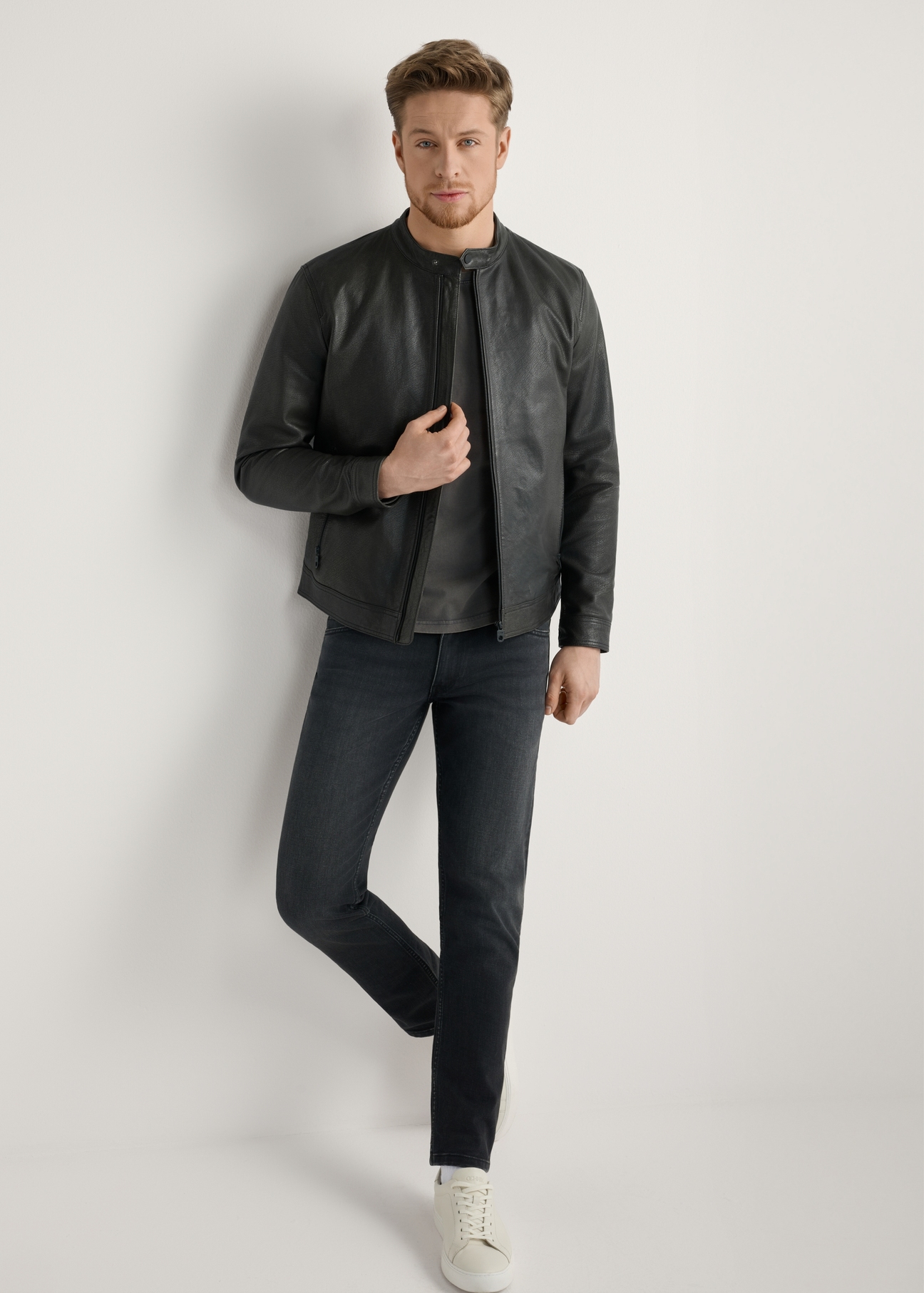 Czarna kurtka skórzana męska KURMS-0406-99(W26) - widok produktu z przodu, na modelu, na jasnym tle. Widoczna cała sylwetka.