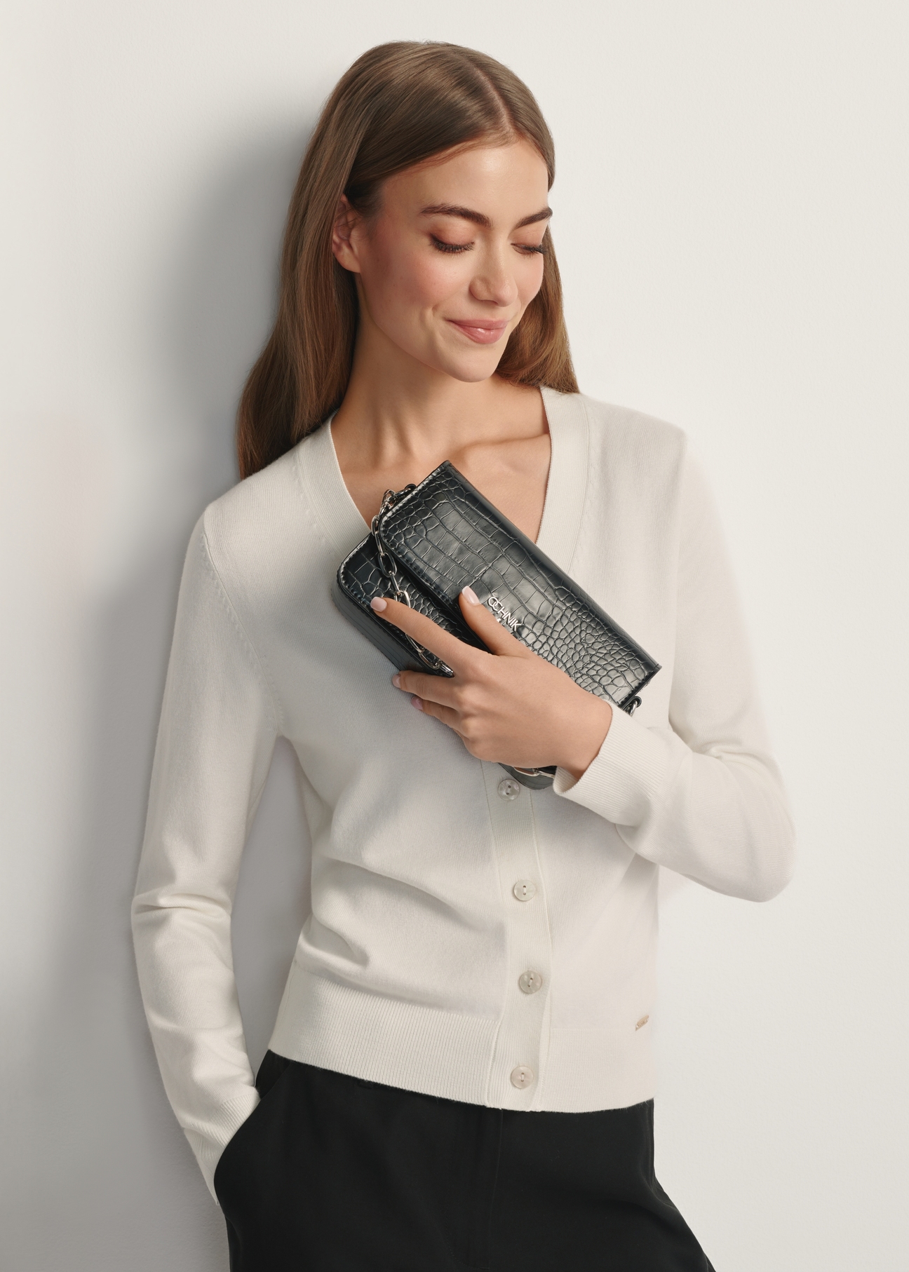 Mała torebka damska croco TOREC-1171-9G(W26) - widok produktu z przodu, trzymanego przez modelkę w ręku, na jasnym tle. Widoczna połowa sylwetki.