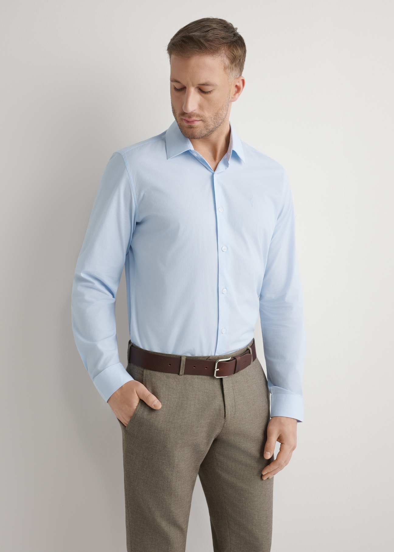 Jasnoniebieska koszula męska w paski KOSMT-0357-7A(W26), widok produktu z przodu na modelu. Widoczna połowa sylwetki.