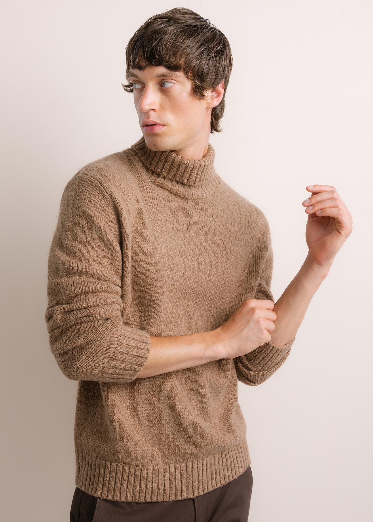 Męski sweter z golfem w kolorze camelowym SWEMT-0209-1D(Z26), widok produktu skosem na modelu. Widoczna połowa sylwetki.