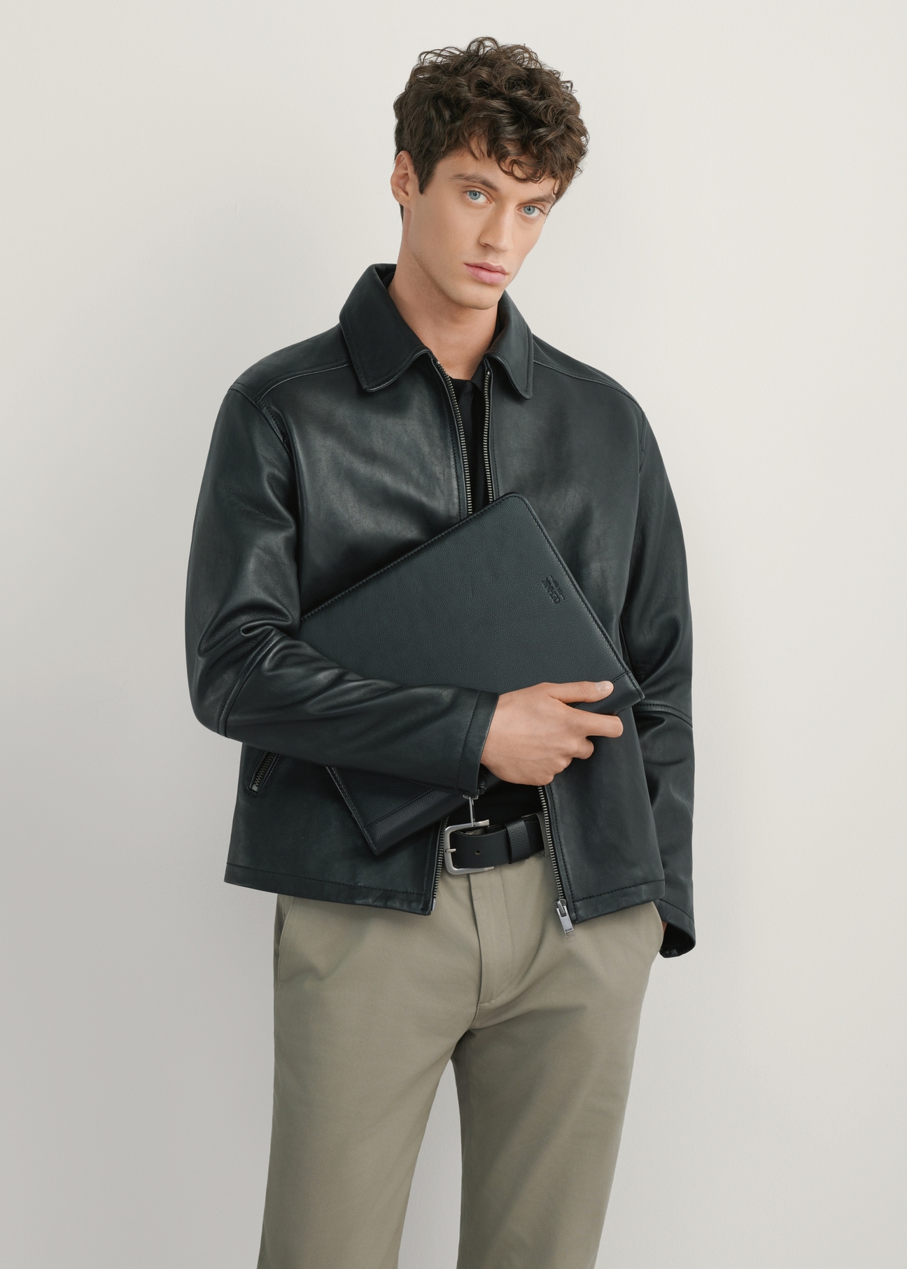 Czarna skórzana aktówka męska TORMS-0410R-9I(W26), widok produktu od przodu na modelu, widoczna połowa sylwetki.