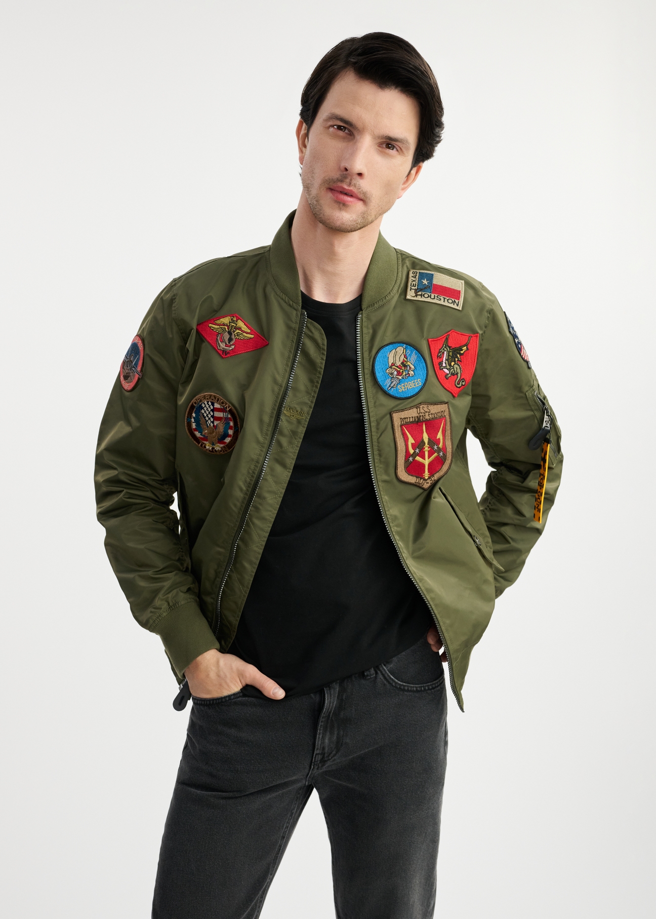 Oliwkowa męska kurtka pilotka TOP GUN KURMT-0381-57(W25) - widok z przodu na modelu na białym tle. Widoczna połowa sylwetki. 