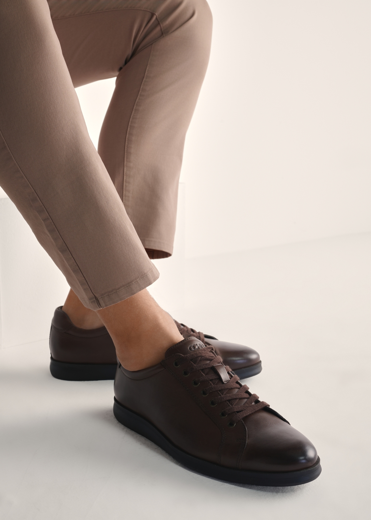 Brązowe skórzane buty męskie BUTYM-0513-89(Z25), widok produktu na stopach modela na jasnym tle.