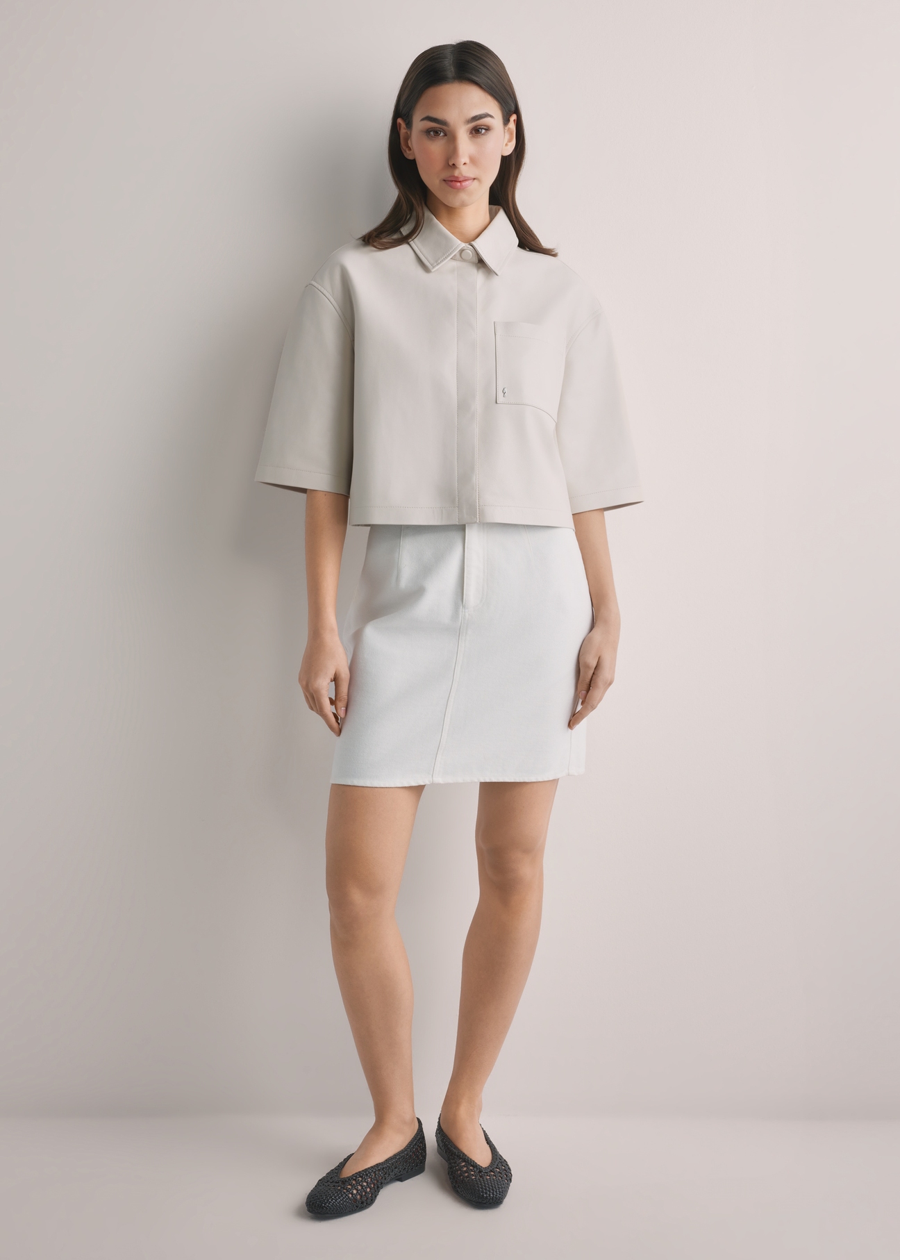 Kremowa denimowa spódnica mini SPCDT-0126-0B(W26), widok produktu z przodu na modelce. Widoczna cała sylwetka.