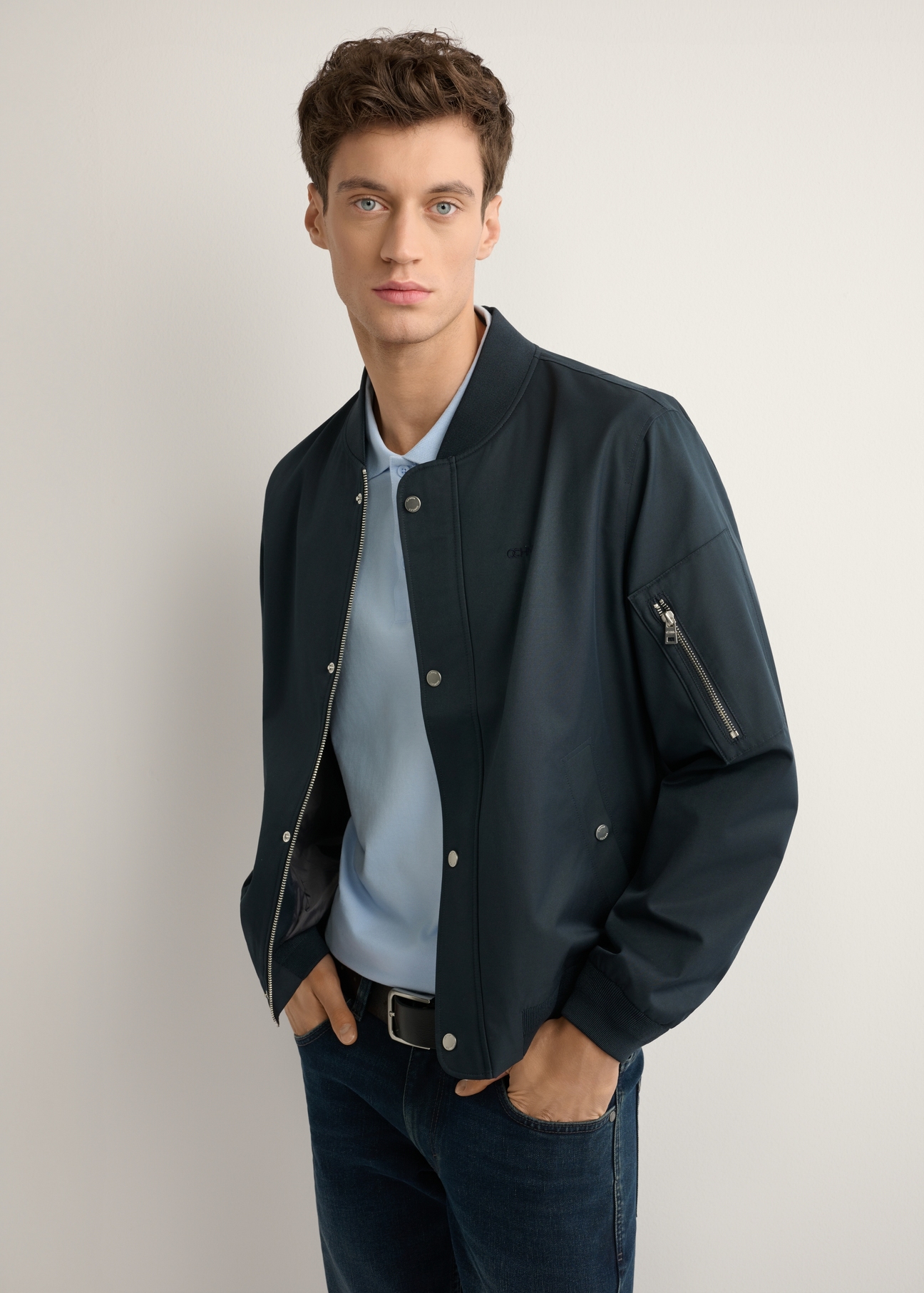 Granatowa przejściowa kurtka męska KURMT-0403-7D(W26), widok produktu z boku na modelu. Widoczna połowa sylwetki.