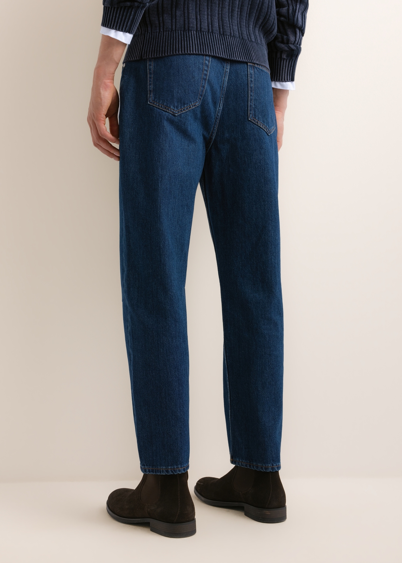 Niebieskie jeansowe spodnie męskie JEAMT-0026-7C(Z26), widok produktu z tyłu na modelu. Widoczna połowa sylwetki.
