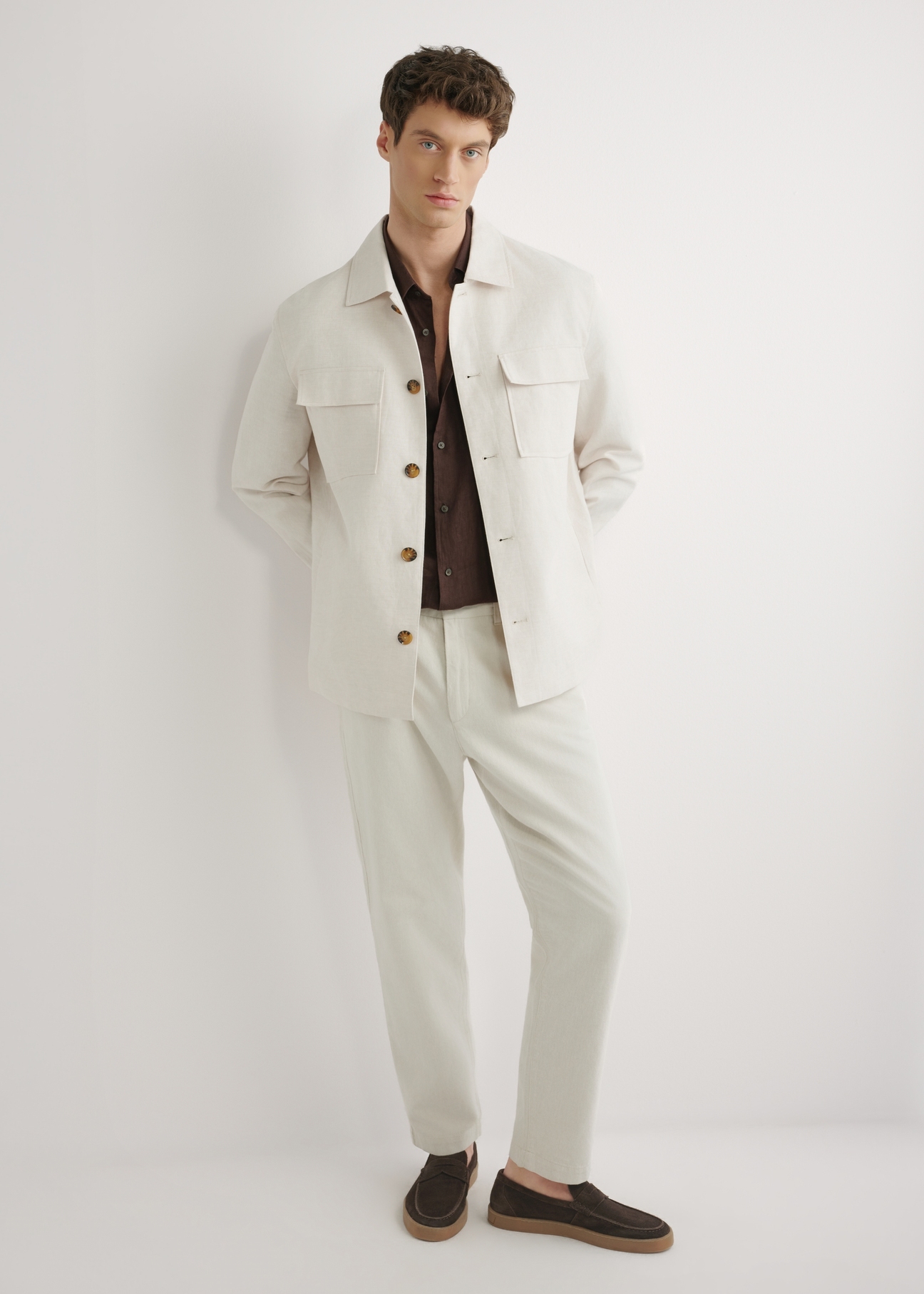 Jasnobeżowa lniana kurtka męska KURMT-0420-1A(W26) - widok produktu z przodu, na modelu, na jasnym tle. Widoczna cała sylwetka. 