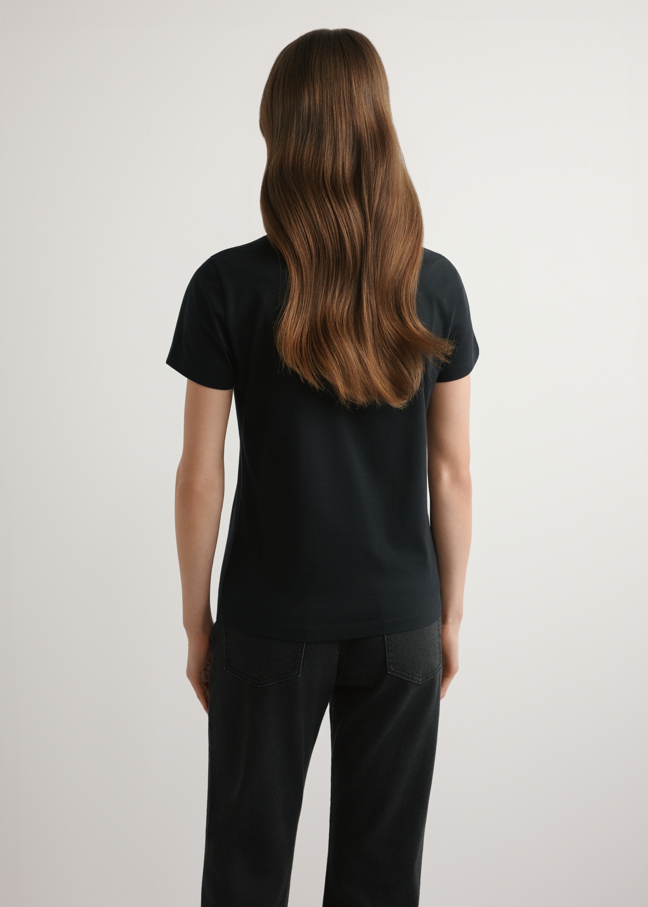 Czarny T-shirt damski z logo TSHDT-0155-99(W26), widok produktu z tyłu na modelce. Widoczna połowa sylwetki.