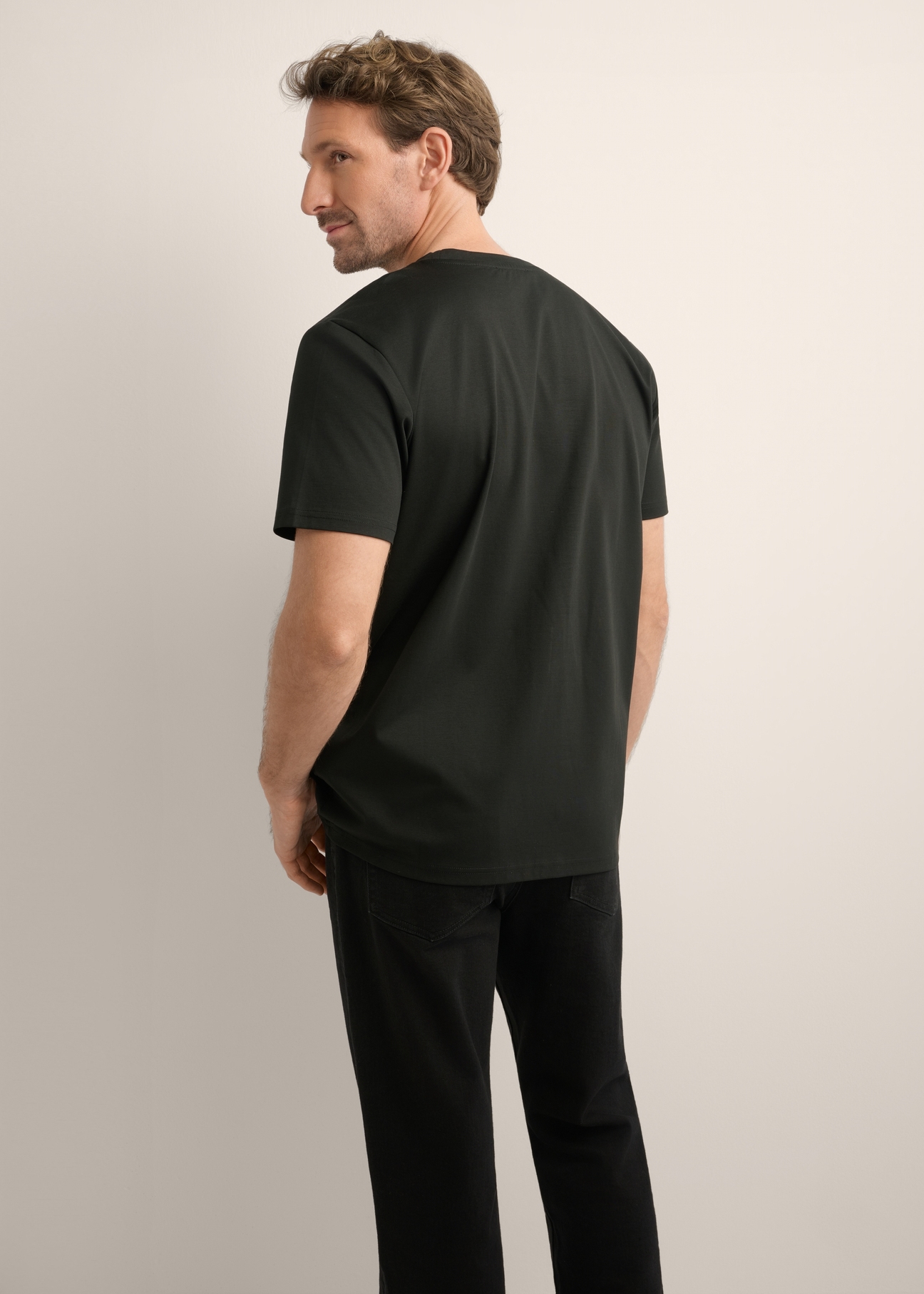 Czarny t-shirt męski z bawełny merceryzowanej TSHMT-0156-99(Z26), widok produktu z tyłu na modelu. Widoczna połowa sylwetki.