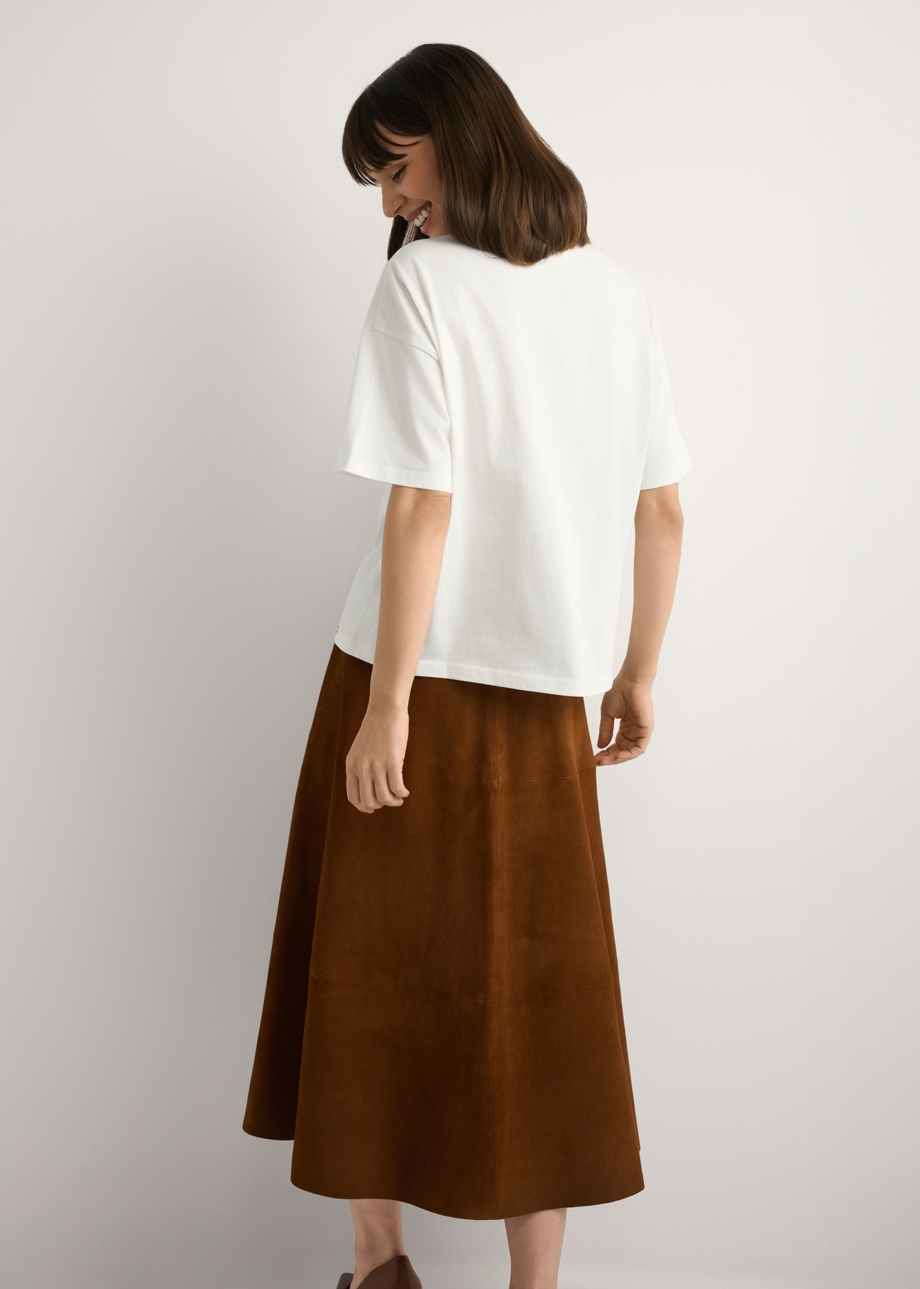 Biały T-shirt damski z nadrukiem TSHDT-0153-0B(W26), widok produktu z tyłu na modelce. Widoczna połowa sylwetki.