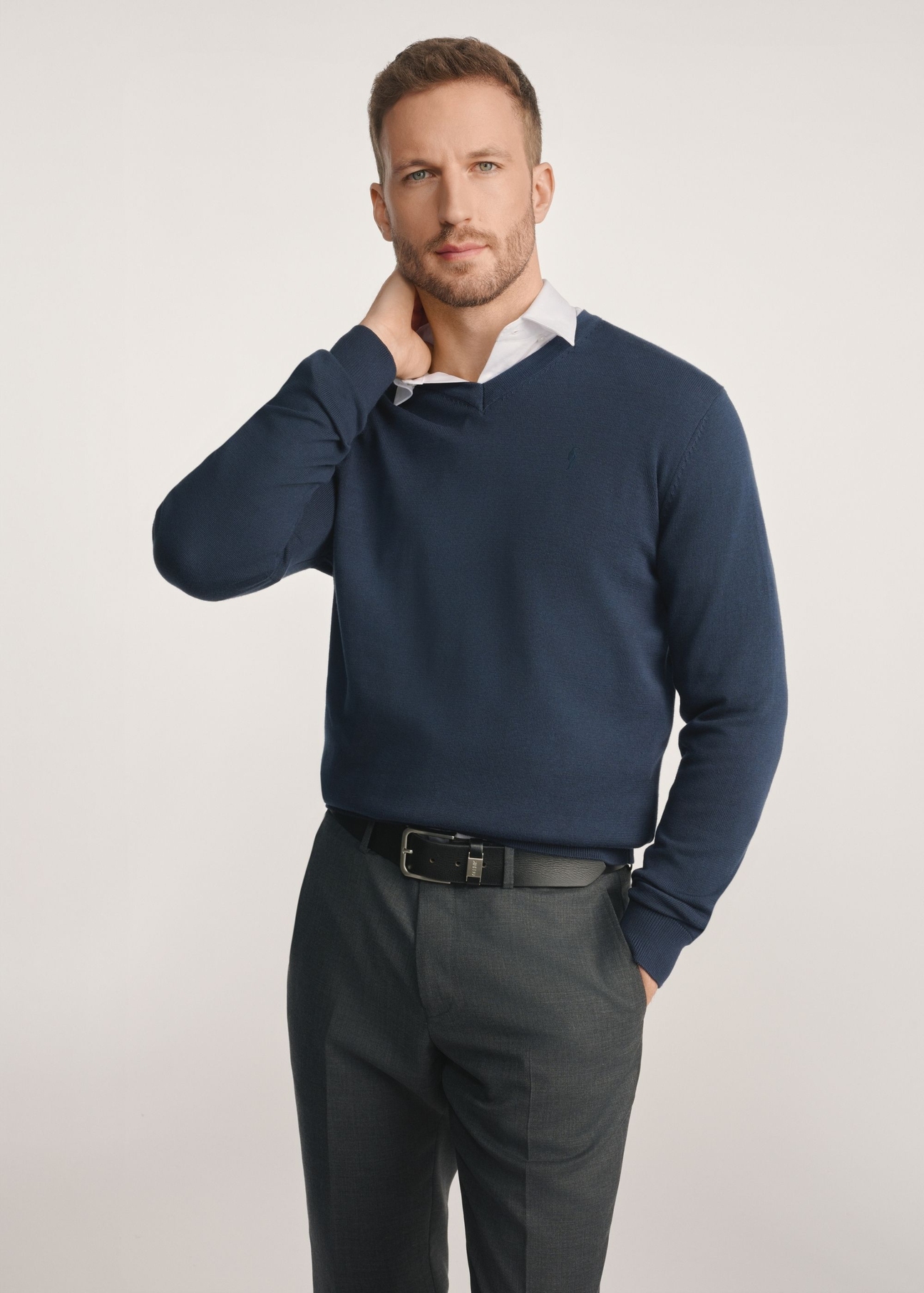 Granatowy sweter męski z logo SWEMT-0159A-7E(Z26) - widok produktu z przodu na modelu na białym tle. Widoczna połowa sylwetki.