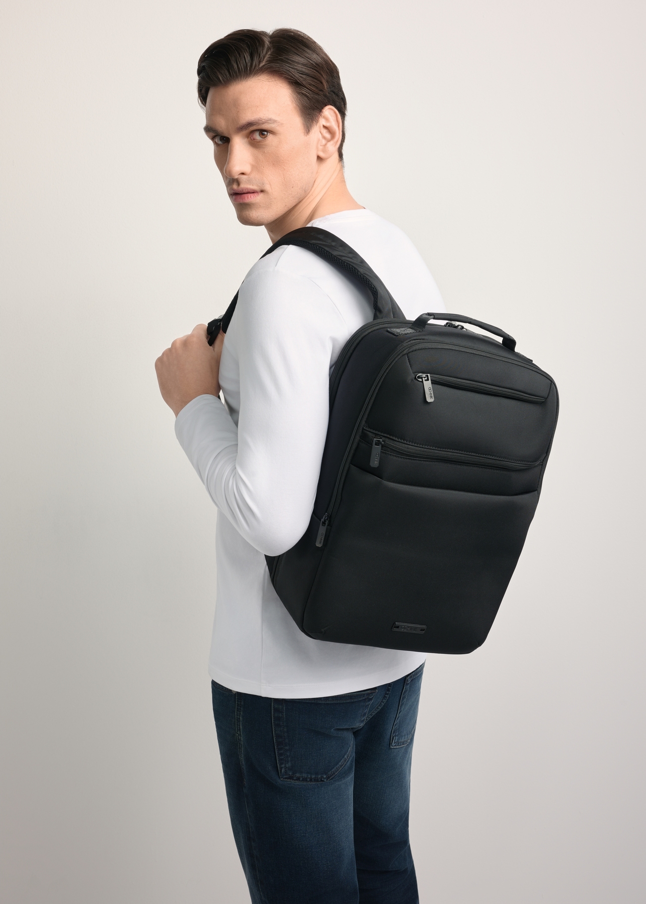 Czarny plecak męski TORMN-0368-99(Z25) - widok produktu po skosie, na jasnym tle. Widoczna połowa sylwetki. 