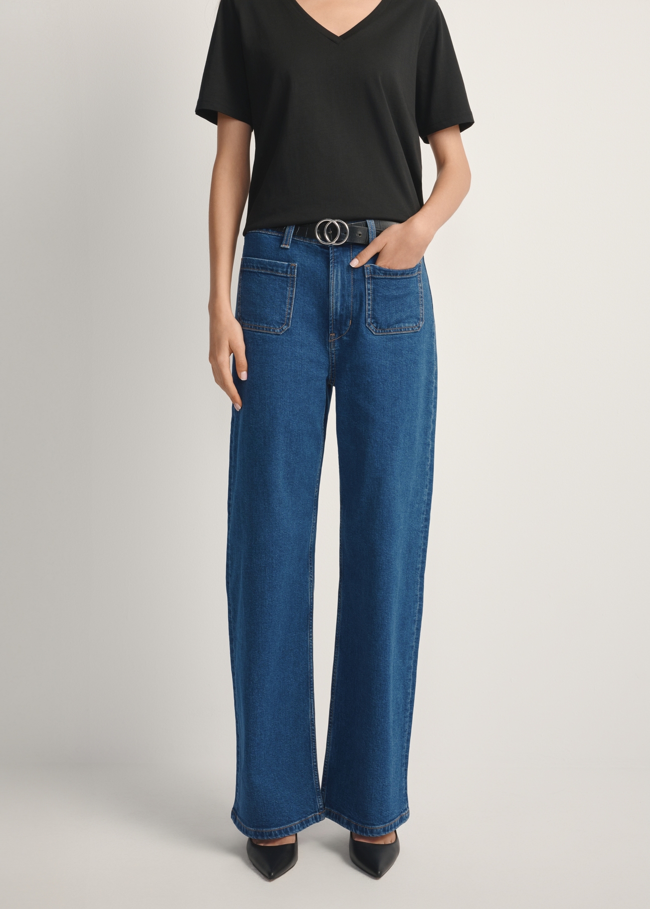 Niebieskie jeansowe spodnie damskie JEADT-0014-7H(W26), widok produktu z przodu na modelce. Widoczna połowa sylwetki.