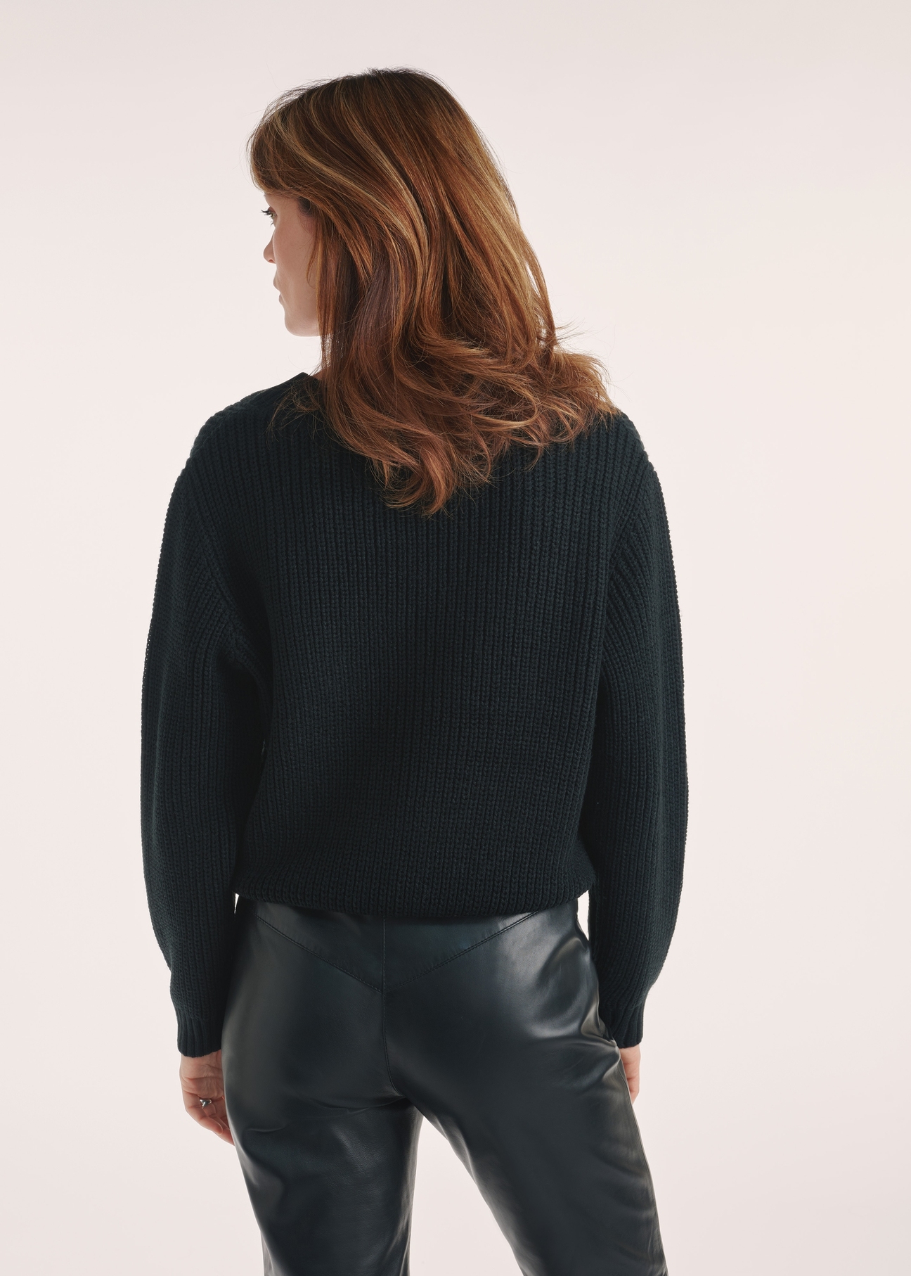 Czarny sweter dekolt V damski SWEDT-0162-99(Z24), widok produktu z tyłu na modelce, widoczne pół sylwetki.