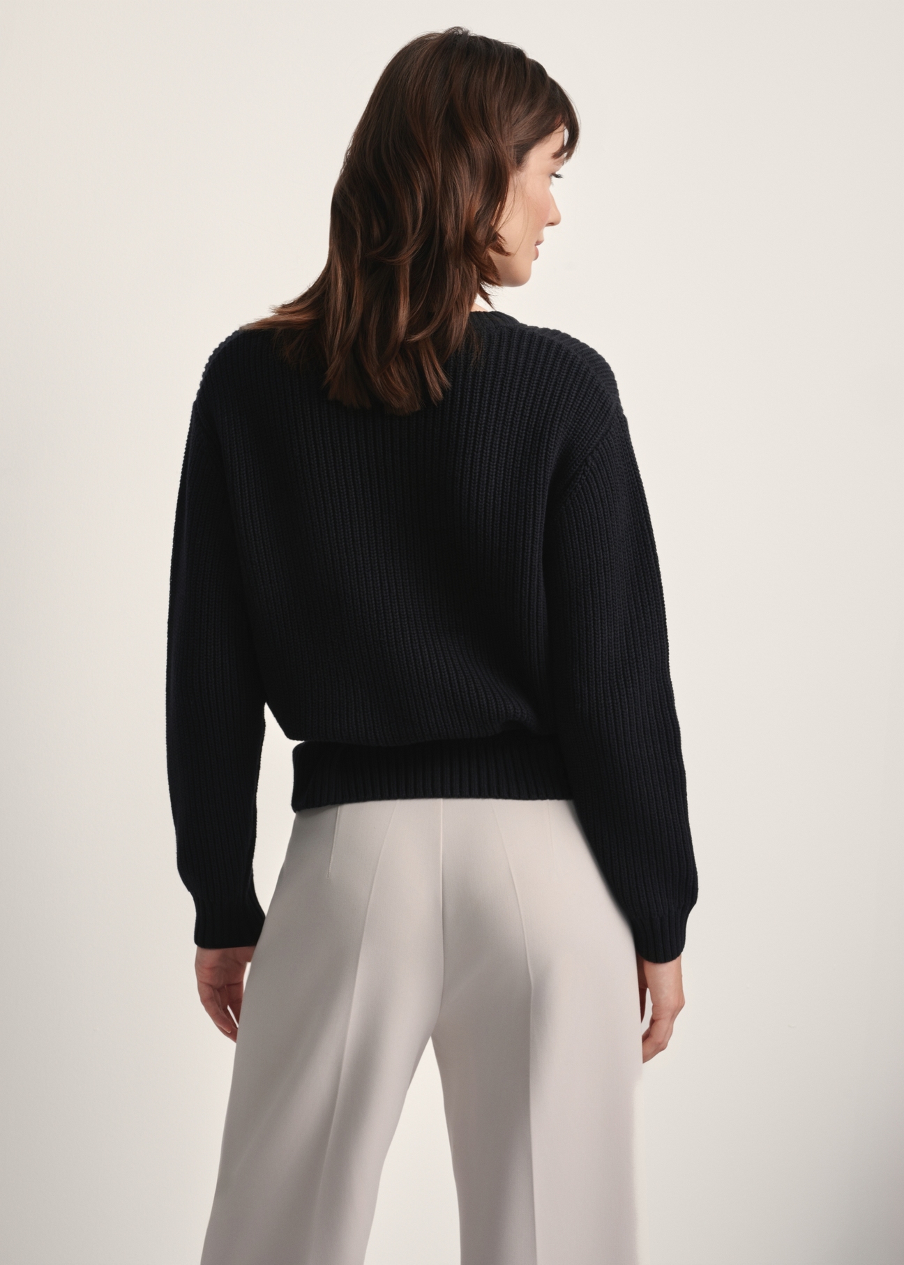 Czarny sweter damski SWEDT-0238-99(Z25), widok produktu z tyłu na modelce. Widoczna połowa sylwetki.