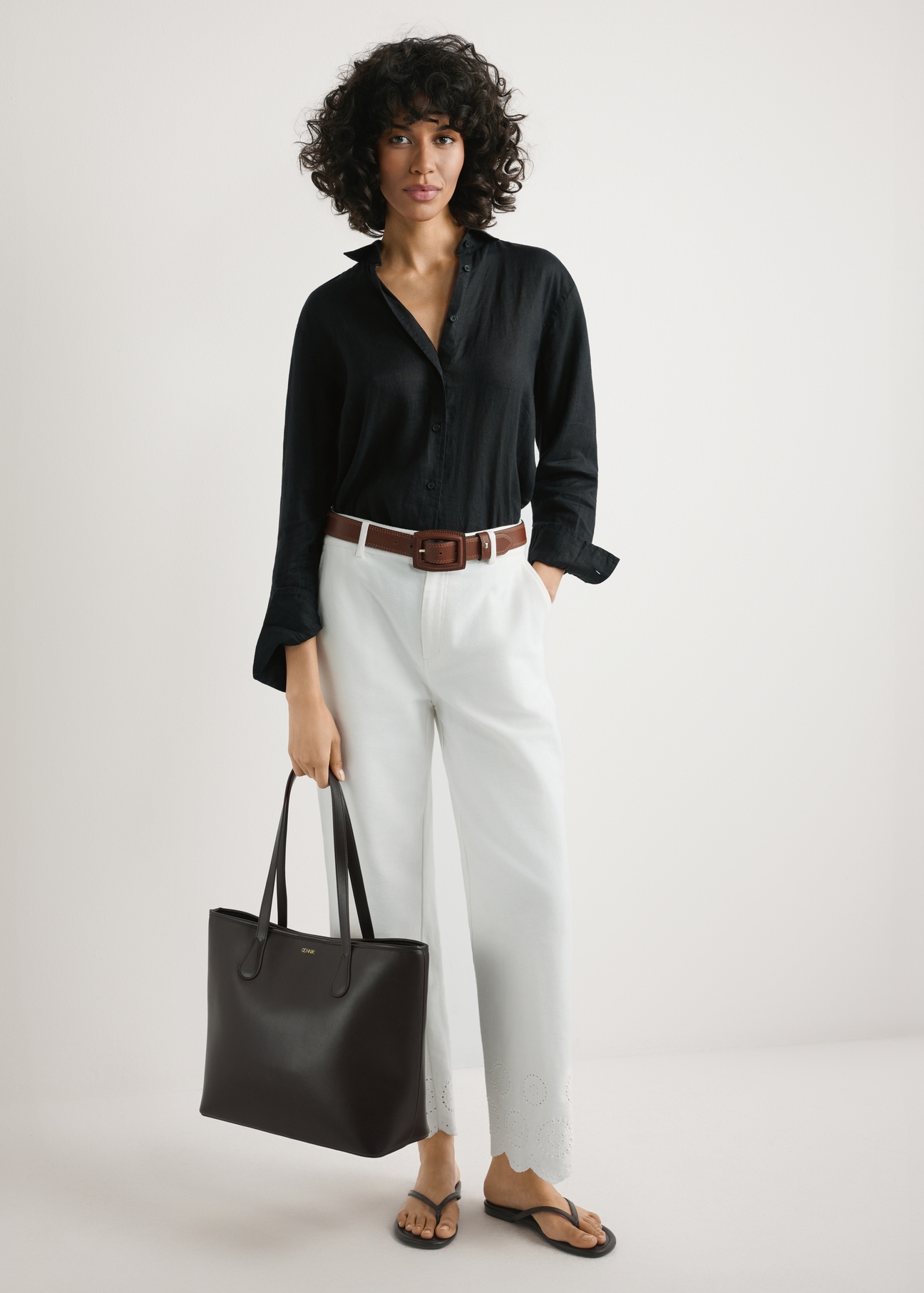 Brązowa damska torebka shopper TOREC-1235-1H(W26),  widok produktu w rękach modelki. Widoczna cała sylwetka.