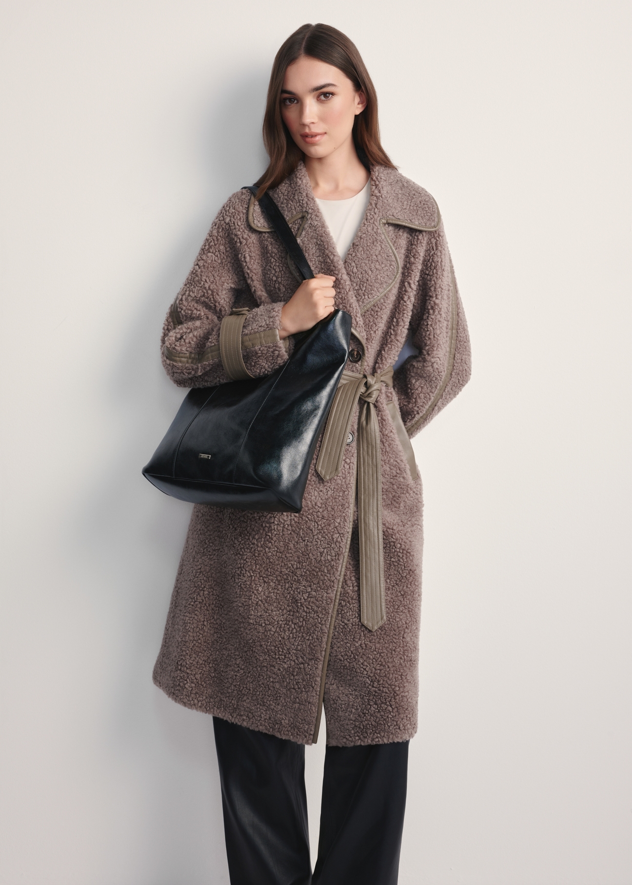 Czarna damska torebka shopper TOREC-1086-99(Z25) - widok produktu z przodu na modelce na białym tle. Widoczna cała sylwetka. 
