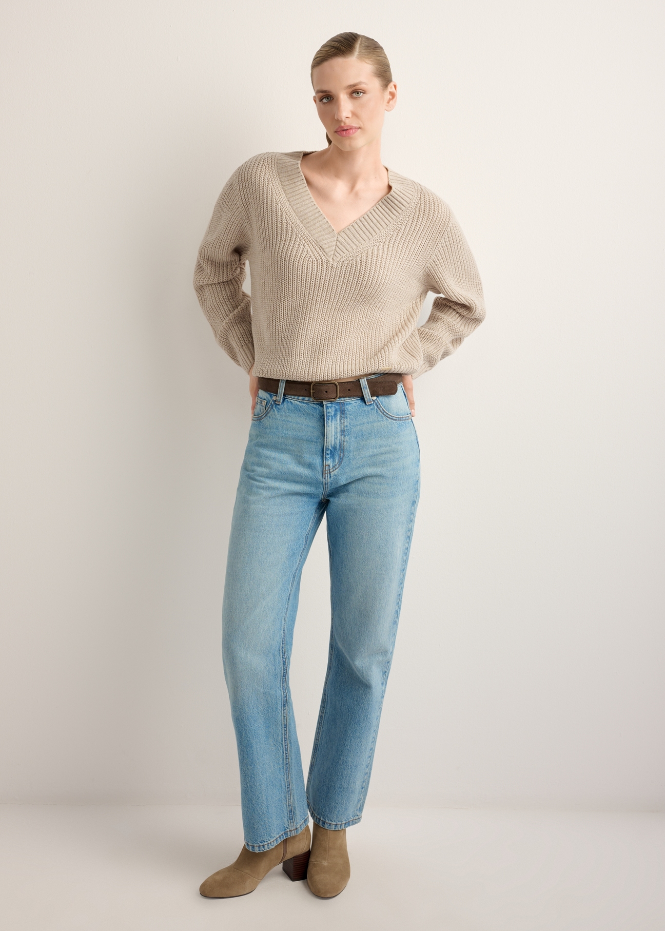 Sweter damski w kolorze chłodnego beżu SWEDT-0162-1J(Z26), widok produktu z przodu na modelce. Widoczna cała sylwetka. 