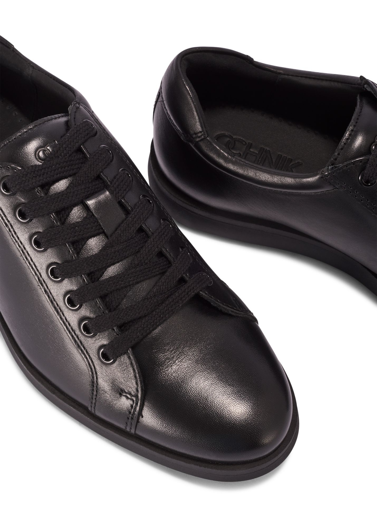 Czarne skórzane buty męskie BUTYM-0513-99(Z25) - zbliżenie na produkt z góry na białym tle. 
