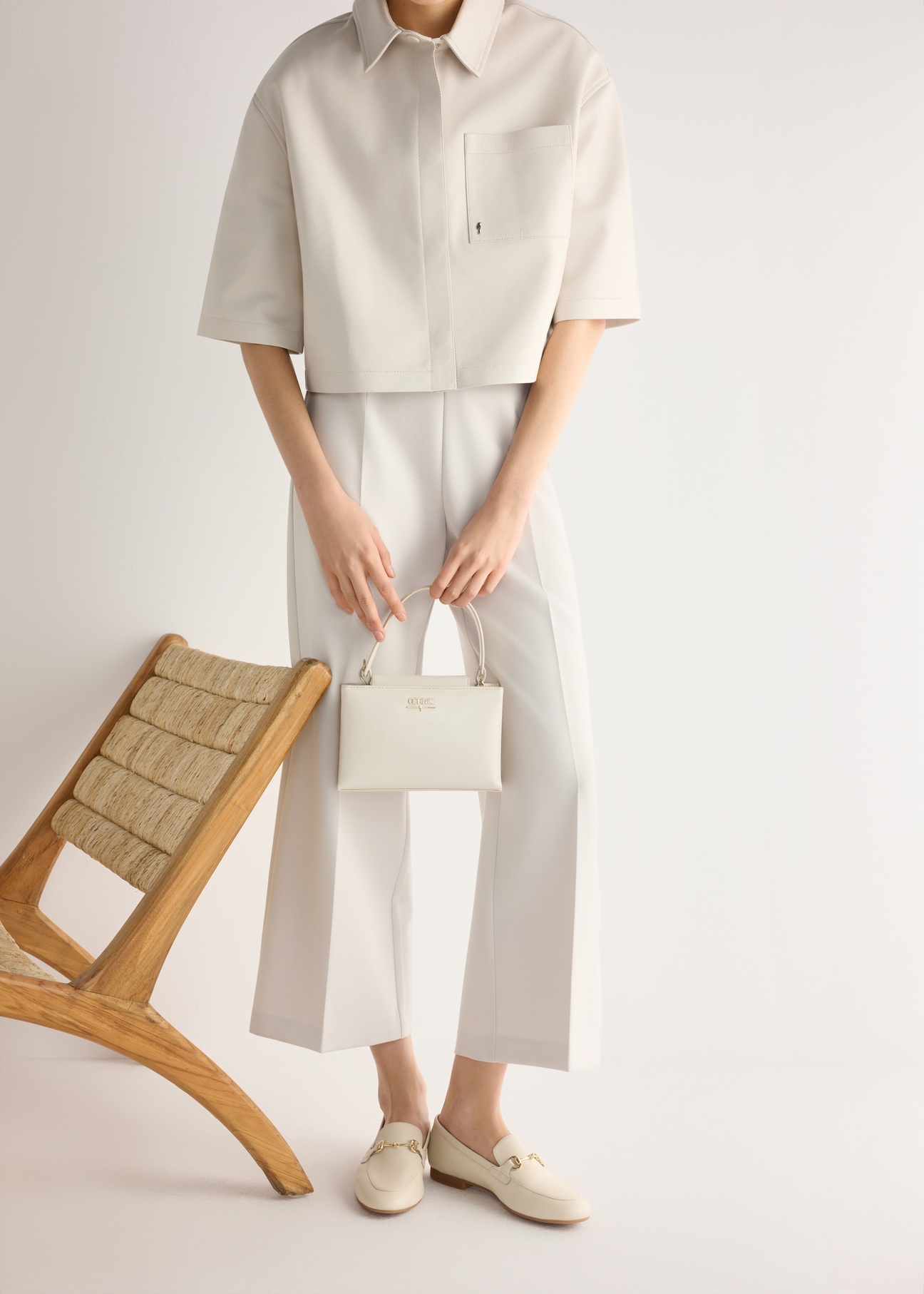 Skórzane kremowe mokasyny damskie z klamrą BUTYD-0916A-0B(W26), widok produktu od boku na modelce, widoczna połowa sylwetki.