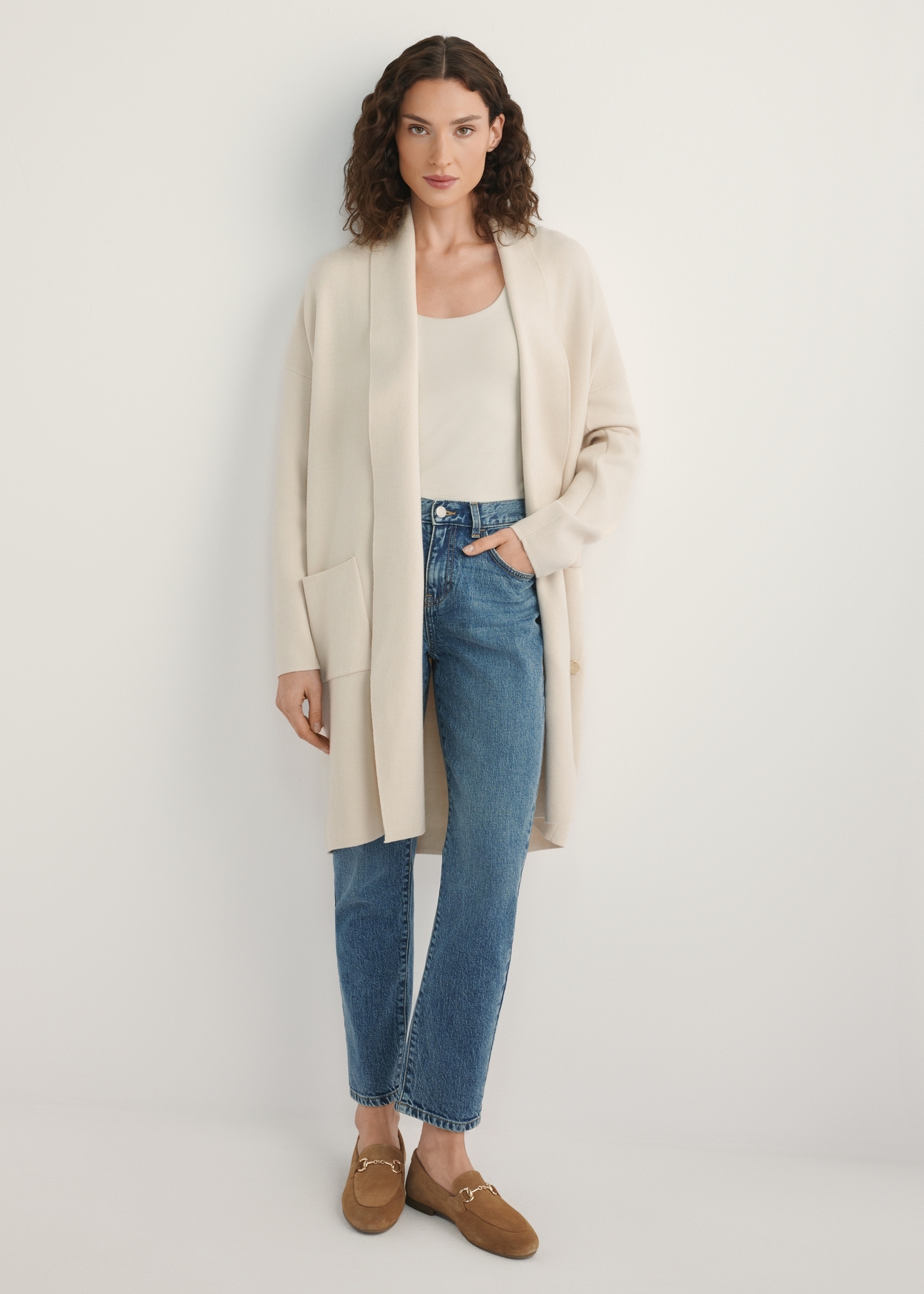 Beżowy kardigan damski KARDT-0041-1A(W26), widok produktu z przodu na modelce. Widoczna połowa sylwetki.