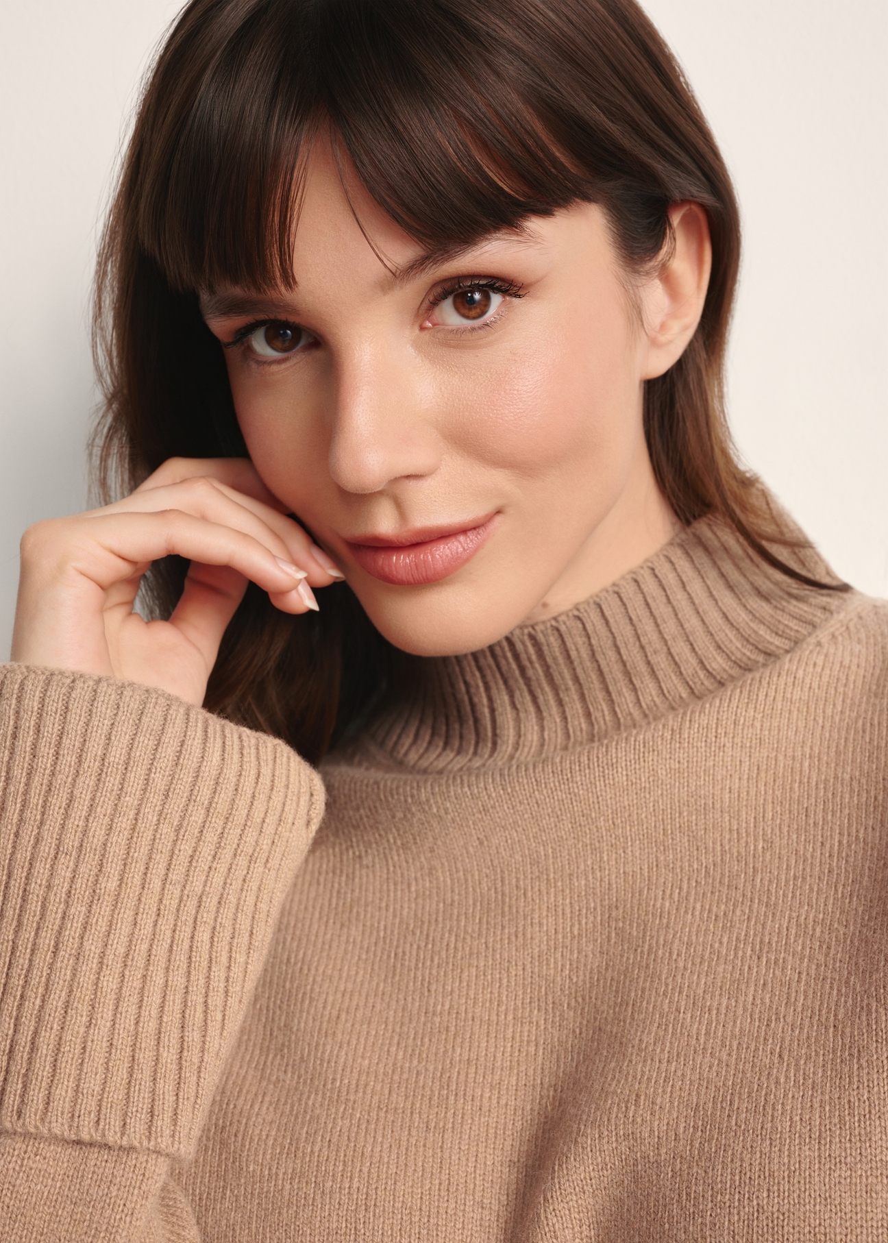 Camelowy sweter damski z wełny SWEDT-0244-24(Z25), zbliżenie produktu na modelce na jasnym tle.