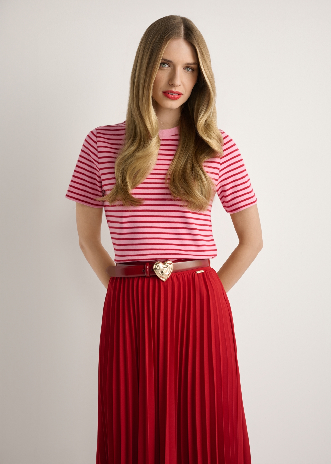 Różowy T-shirt damski w paski TSHDT-0150-5P(W26), widok produktu z przodu na modelce. Widoczna połowa sylwetki.