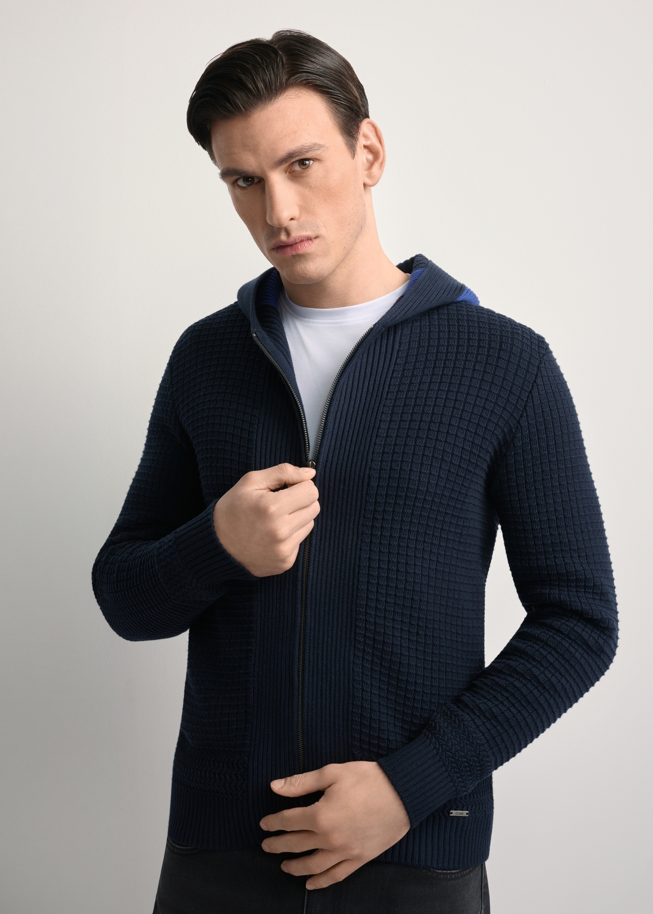 Granatowy sweter męski z kapturem SWEMT-0182-68(Z25), zbliżenie na produkt na sylwetce modela.