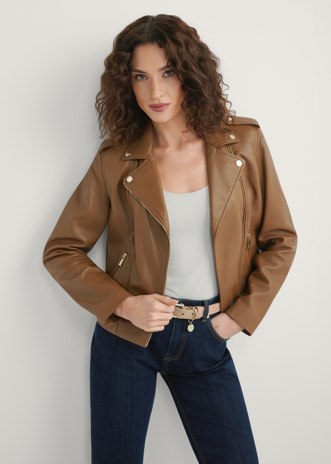 Skórzana kurtka damska w kolorze beżowym KURDS-0601-1B(W26), widok produktu z przodu na modelce. Widoczna połowa sylwetki.