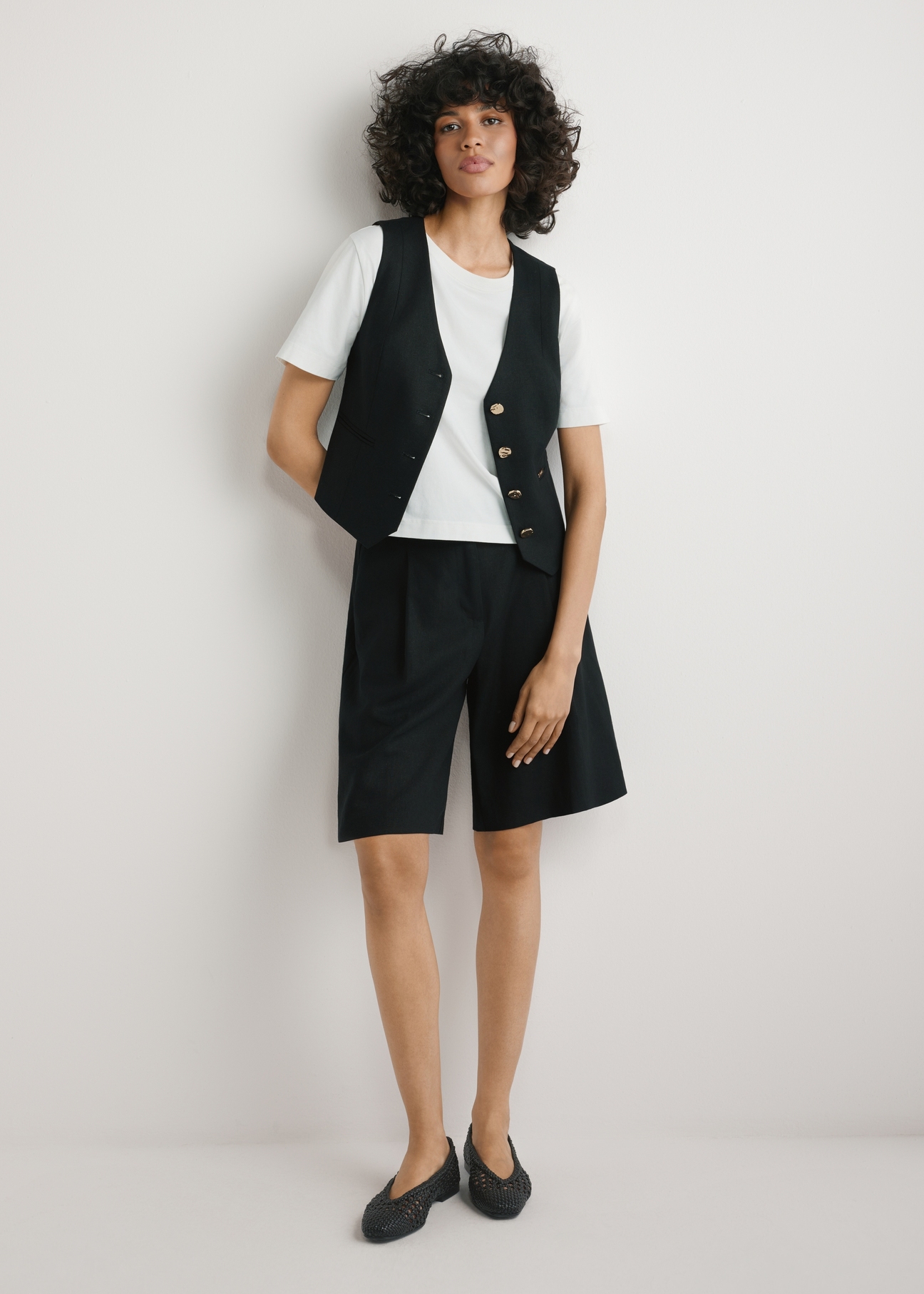 Czarna kamizelka z wiskozy i lnu KAMDT-0038-99(W26) - widok produktu z przodu, na modelce, na jasnym tle, Widoczna cała sylwetka. 