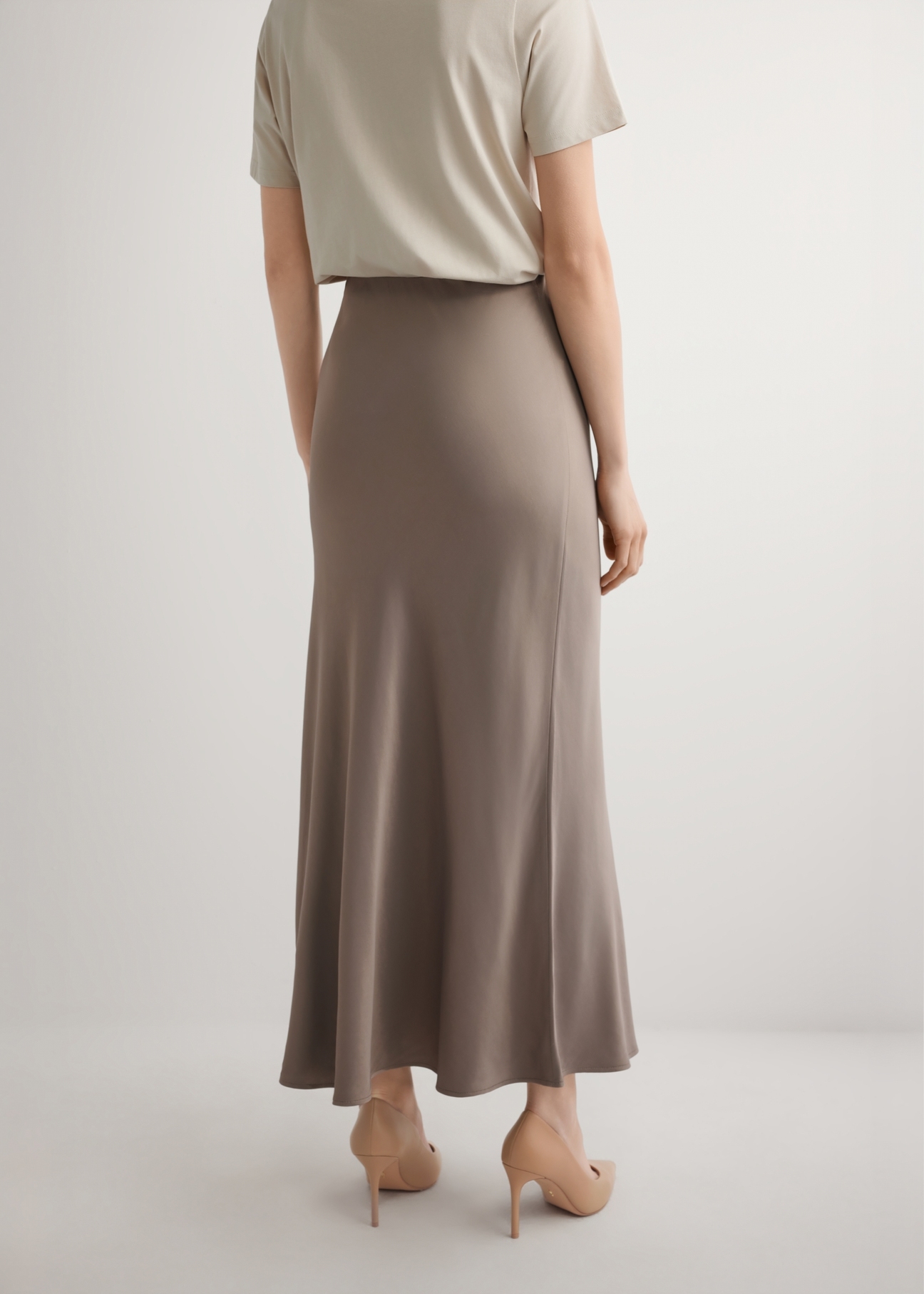 Brązowa spódnica damska SPCDT-0122-1K(W26), widok produktu z tyłu na modelce. Widoczna połowa sylwetki.