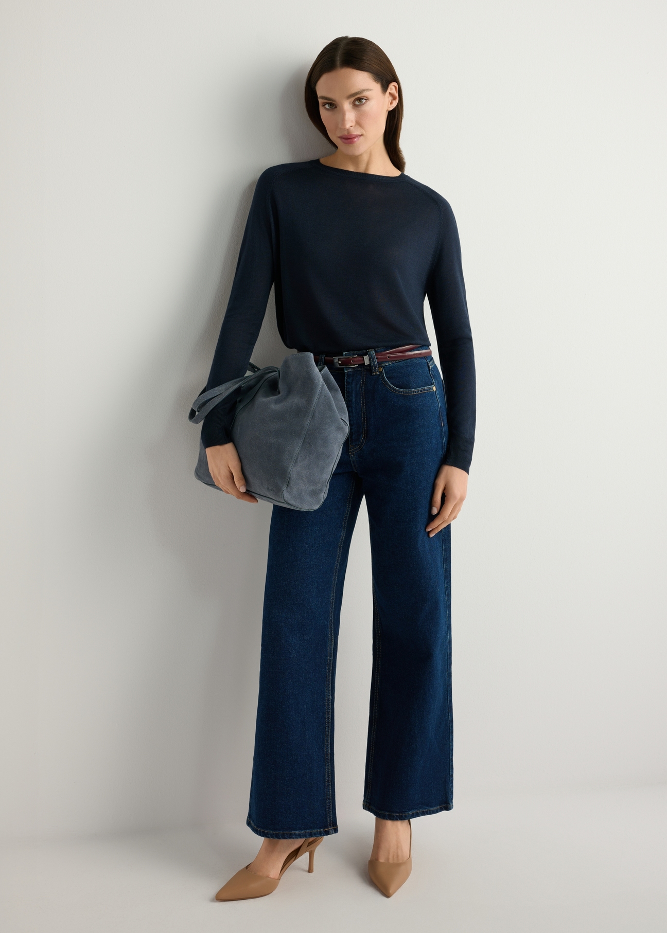 Skórzana ciemnoniebieska torebka damska TORES-1252-7C(W26), widok produktu w dłoni modelki. Widoczna cała sylwetka.