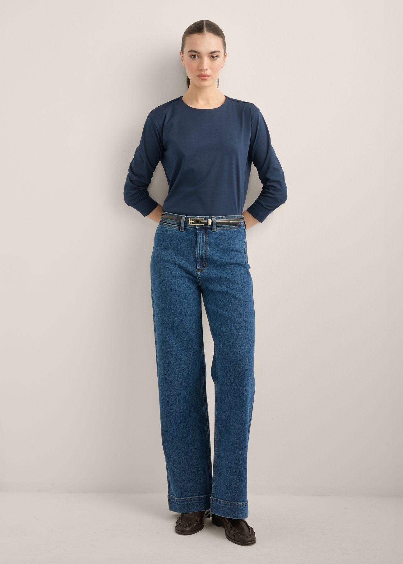 Damskie jeansy wide leg w kolorze ciemnogranatowym JEADT-0019-7D(Z26), widok produktu z przodu na modelce. Widoczna cała sylwetka.