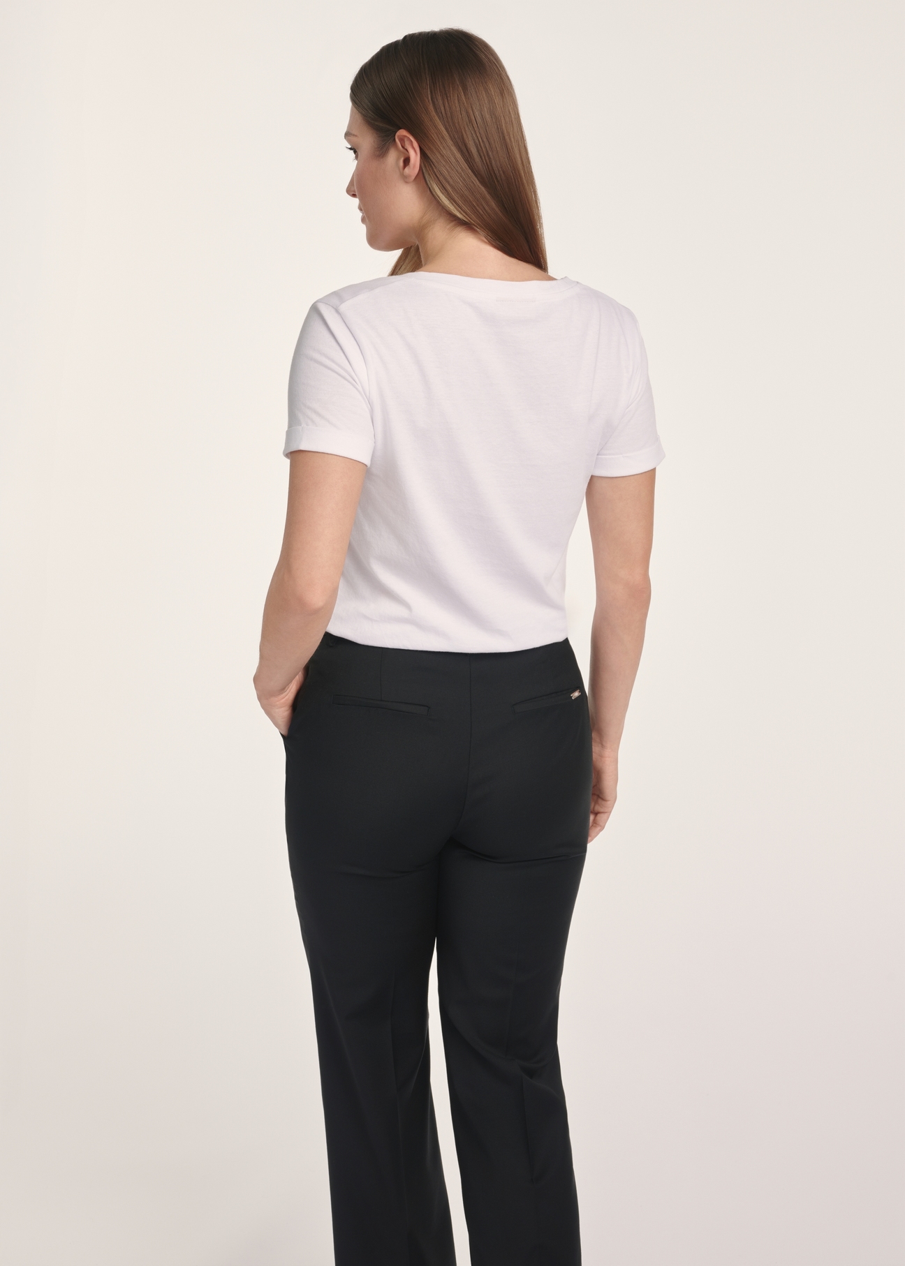 Biały T-shirt damski w serek TSHDT-0118A-11(Z25), widok produktu z tyłu na modelce. Widoczna połowa sylwetki.