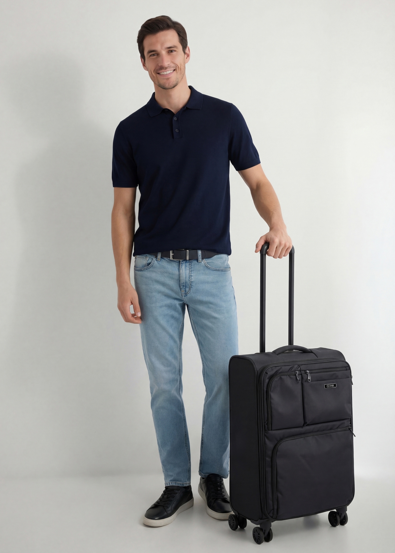 Walizka średnia na kółkach WALNY-0048-99-24(W26), widok produktu skosem obok sylwetki modela.