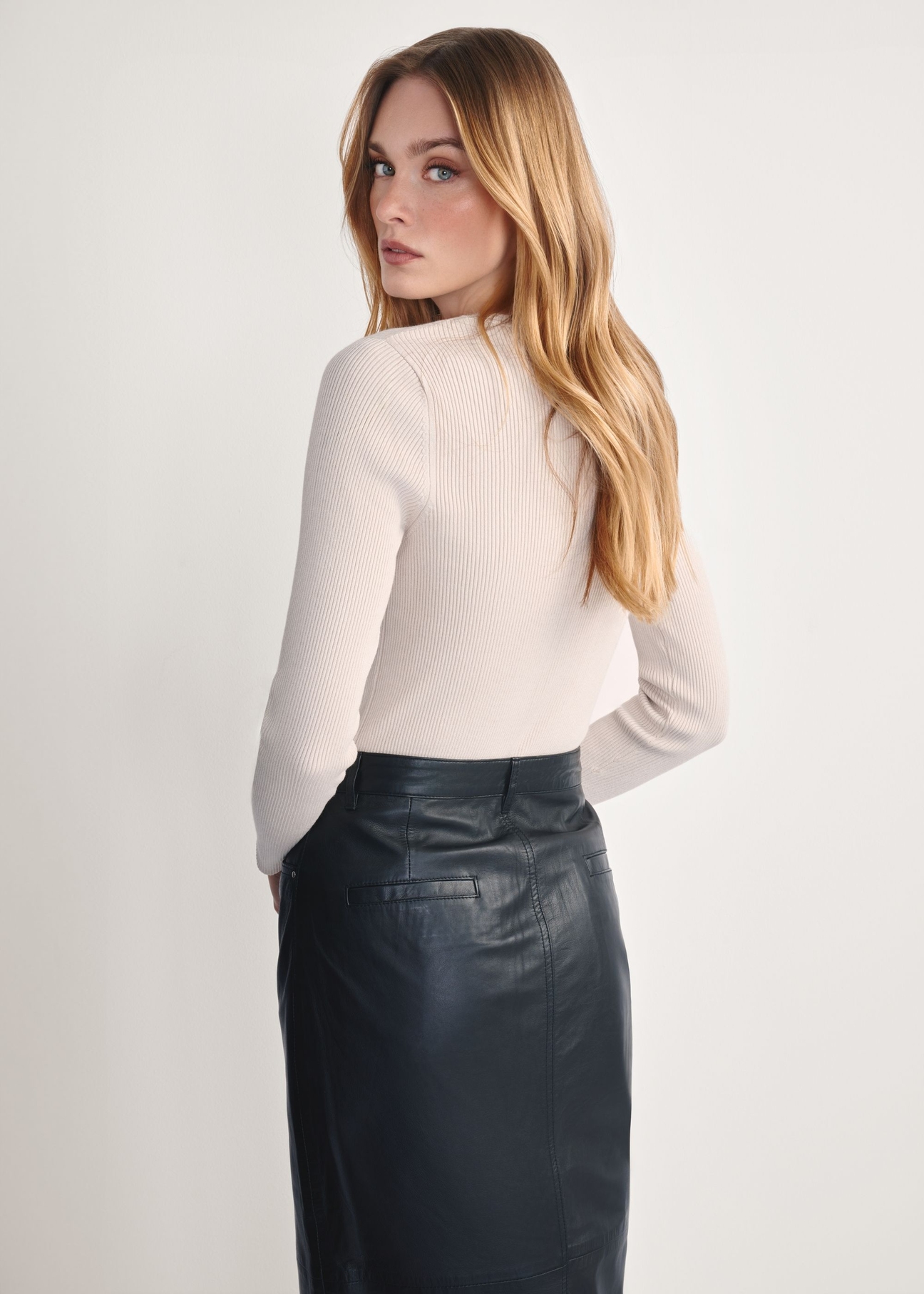 Jasnobeżowy lonsleeve damski LSLDT-0028-80(Z25), widok produktu z tyłu na modelce. Widoczna połowa sylwetki.