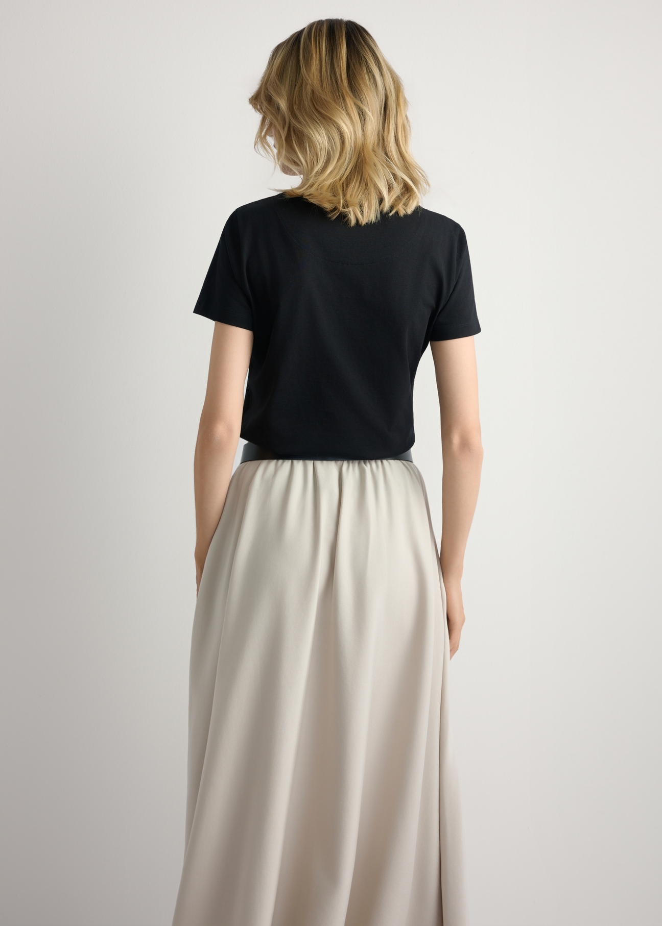 Czarny T-shirt damski z logo TSHDT-0157-99(W26), widok produktu z tyłu na modelce. Widoczna połowa sylwetki.