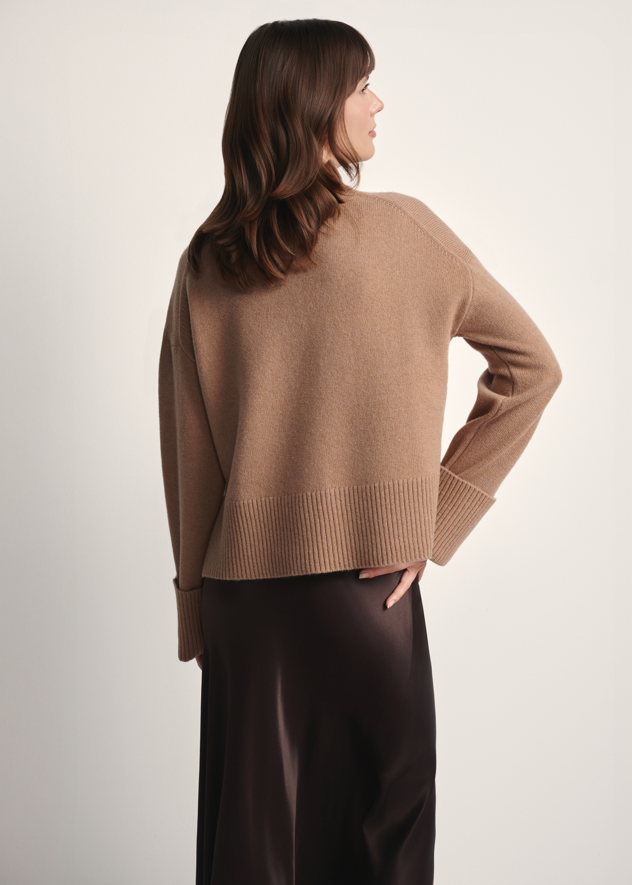 Camelowy sweter damski z wełny SWEDT-0244-24(Z25), widok produktu z tyłu na modelce. Widoczna połowa sylwetki.