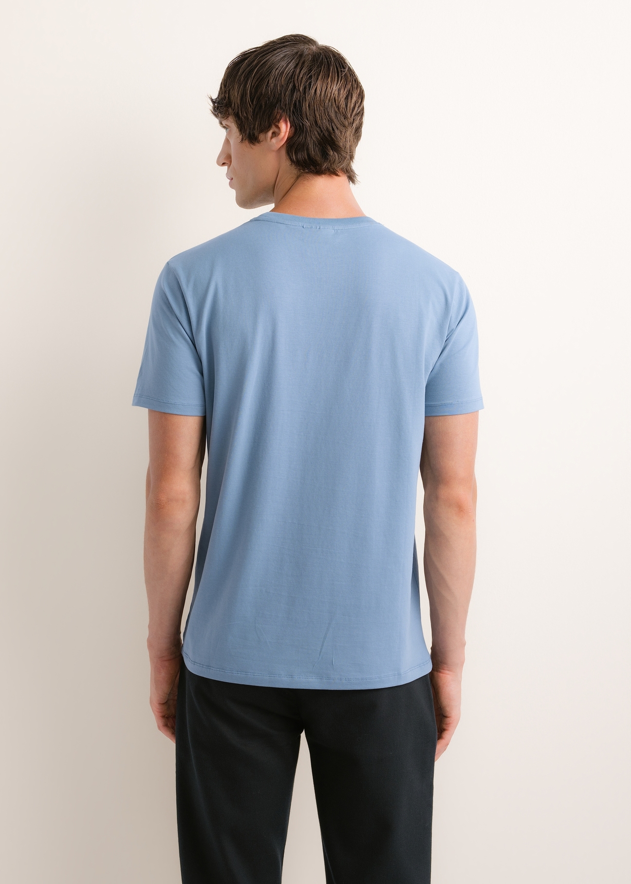 Ciemnoniebieski T-shirt męski TSHMT-0120-7C(Z26), widok produktu z tyłu na modelu. Widoczna połowa sylwetki.