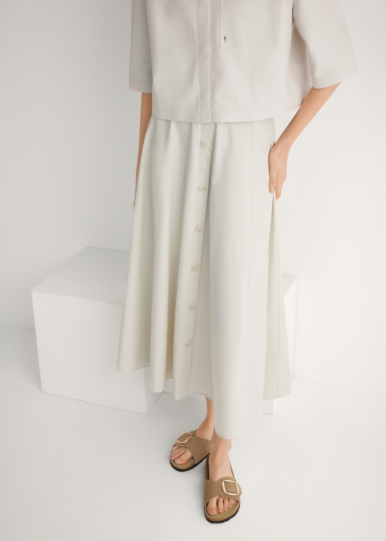 Skórzane klapki damskie w kolorze chłodnego beżu BUTYD-1157-1K(W26), widok produktu z przodu na stopach modelki.