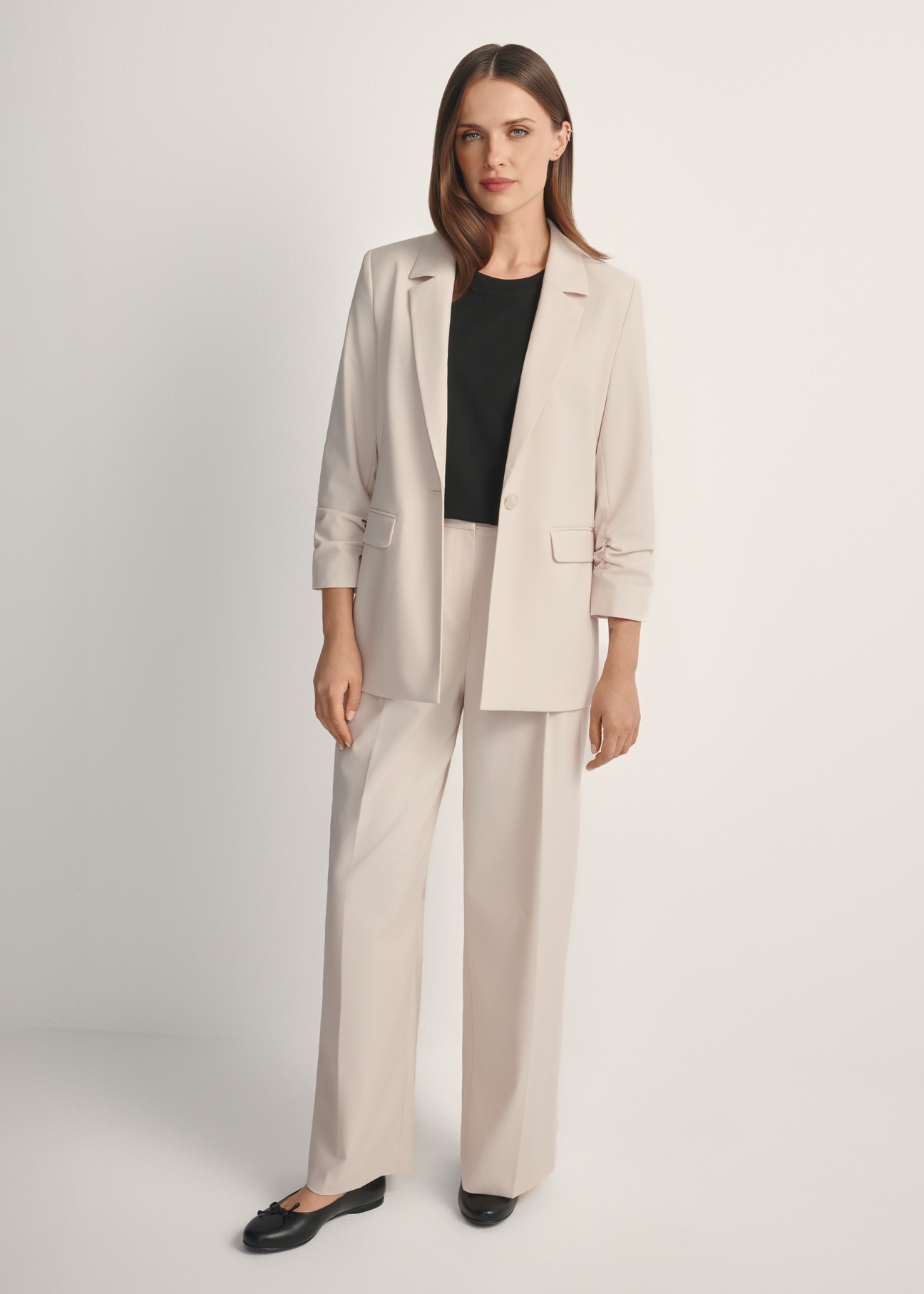 Marynarka damska w kolorze jasnobeżowym ZAKDT-0043-1A(W26), widok produktu od przodu na modelce, widoczna cała sylwetka.