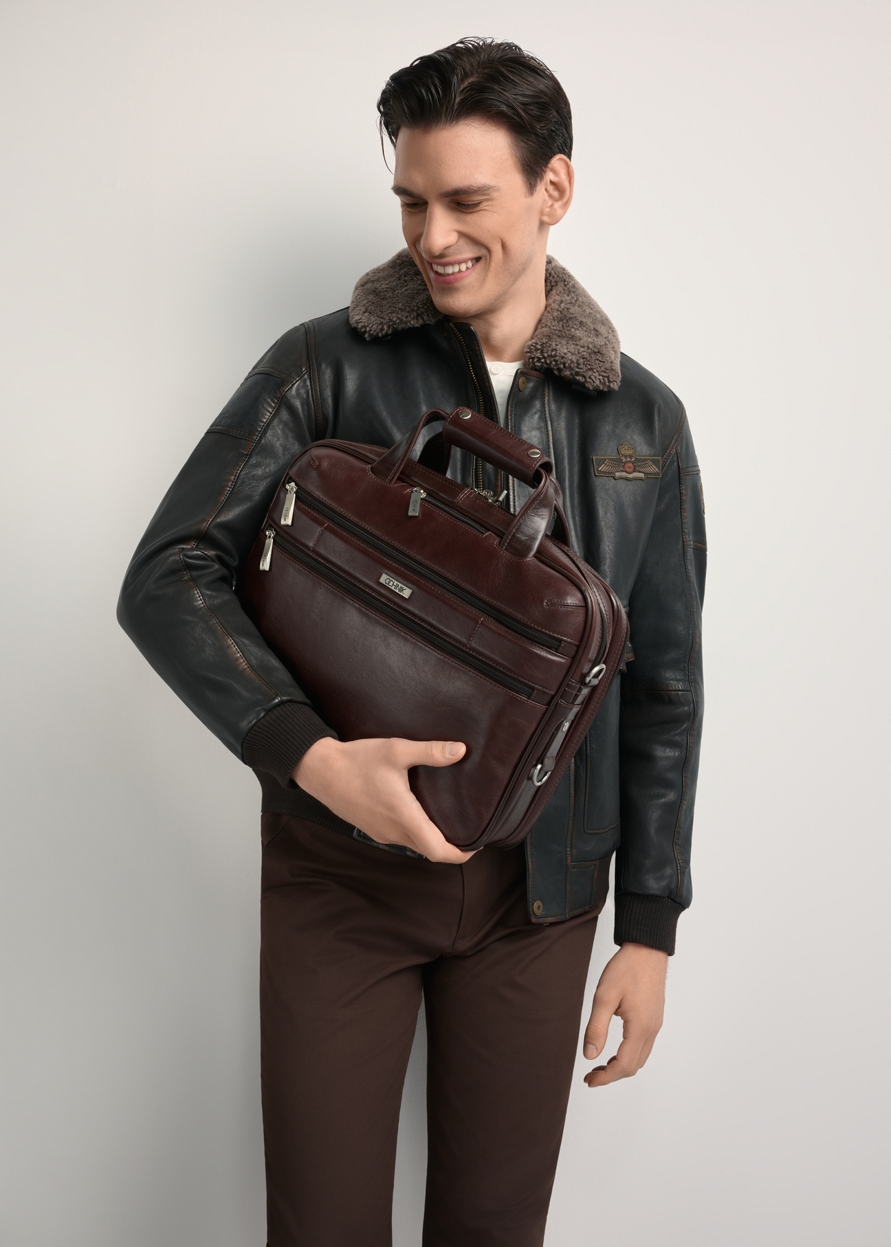 Brązowa skórzana torba męska TORMS-0483-89(Z25) - widok produktu z przodu, na modelu, na białym tle. Widoczna połowa sylwetki. 