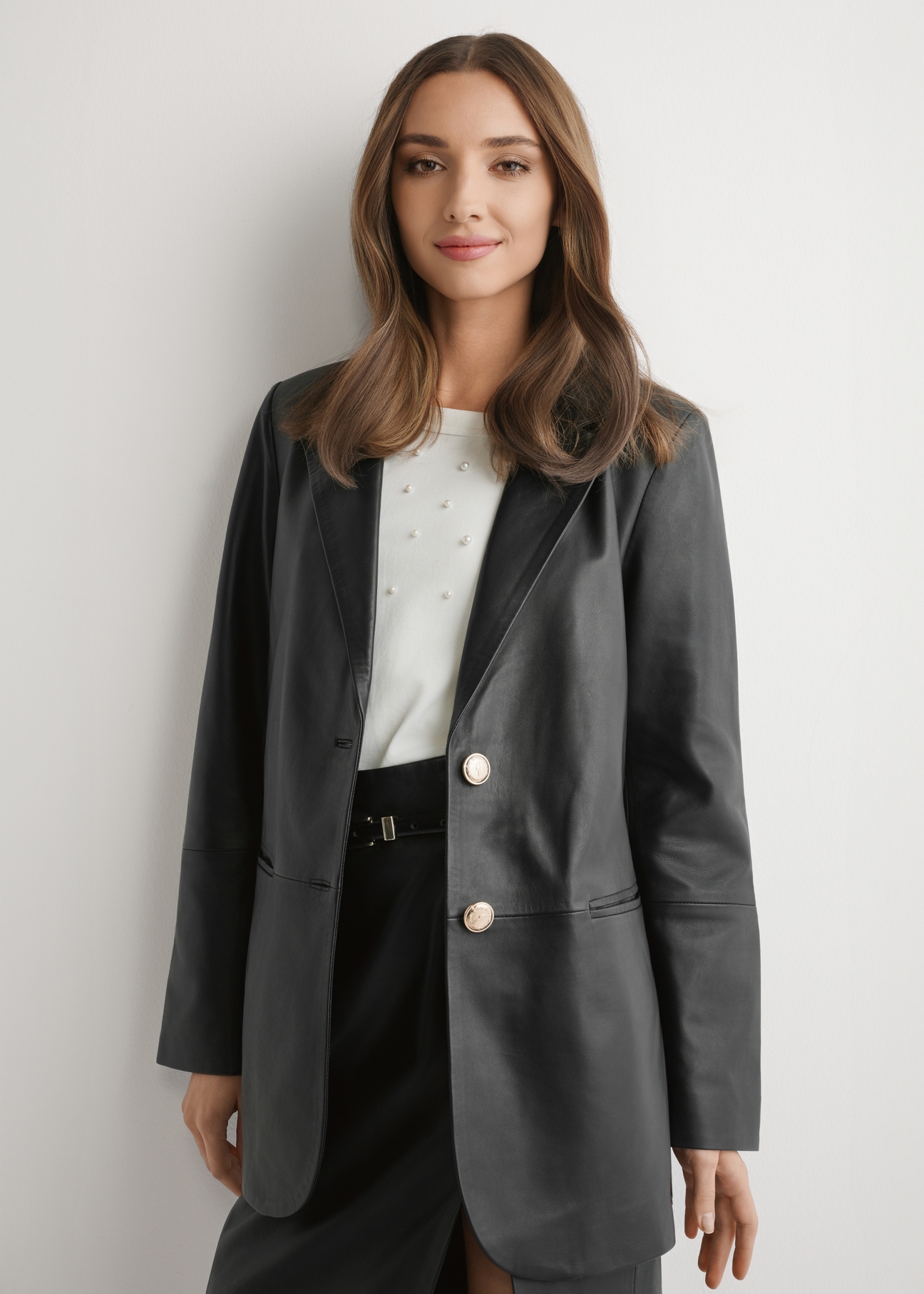 Czarna skórzana marynarka damska KURDS-0606-99(W26) - widok produktu z przodu, na modelu, na jasnym tle. Widoczna sylwetka do kolan.
