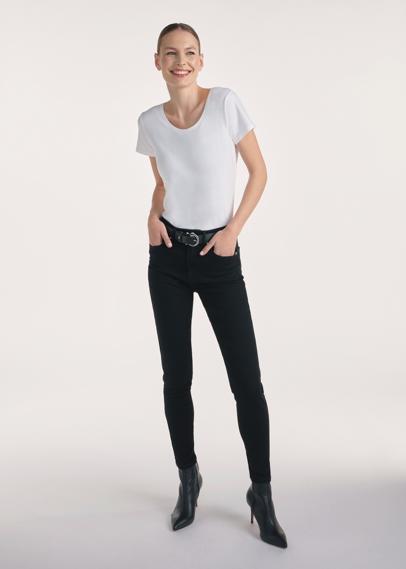 Czarne jeansowe spodnie damskie JEADT-0010A-99(Z25), produkt widoczny z przodu na modelce, widoczna cała sylwetka.
