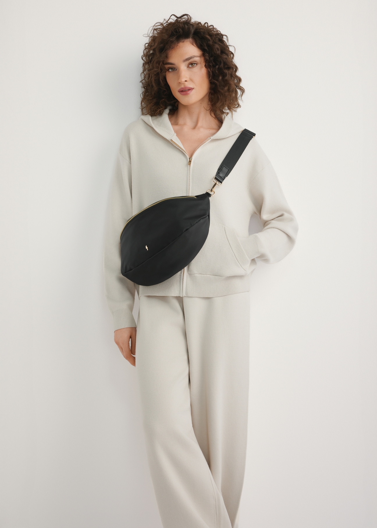 Czarna duża nerka damska TOREN-0345-99(W26) - widok produktu z przodu, na modelce, na jasnym tle. Widoczna cała sylwetka. 