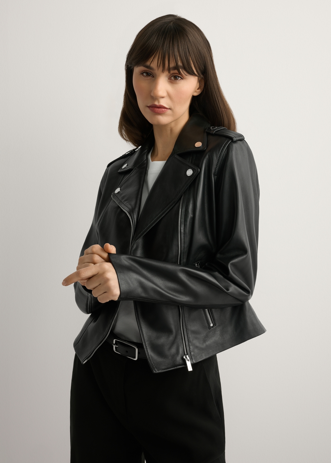 Skórzana kurtka damska w kolorze czarnym KURDS-0601-99(W26), widok produktu z przodu na modelce. Widoczna połowa sylwetki.