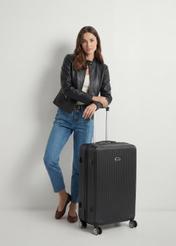 Walizka duża na kółkach WALAB-0053-99-29(W25), widok produktu od przodu przy modelce, widoczna cała sylwetka.