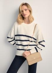 Niewielka beżowa torebka damska TOREC-1015-1B(W26), widok produktu od przodu na modelce, widoczna połowa sylwetki.