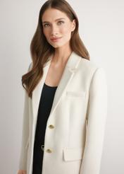 Biały wełniany płaszcz damski PLADT-0072-0B(W26) - widok produktu z przodu, na modelce na jasnym tle. Widoczna połowa sylwetki. 